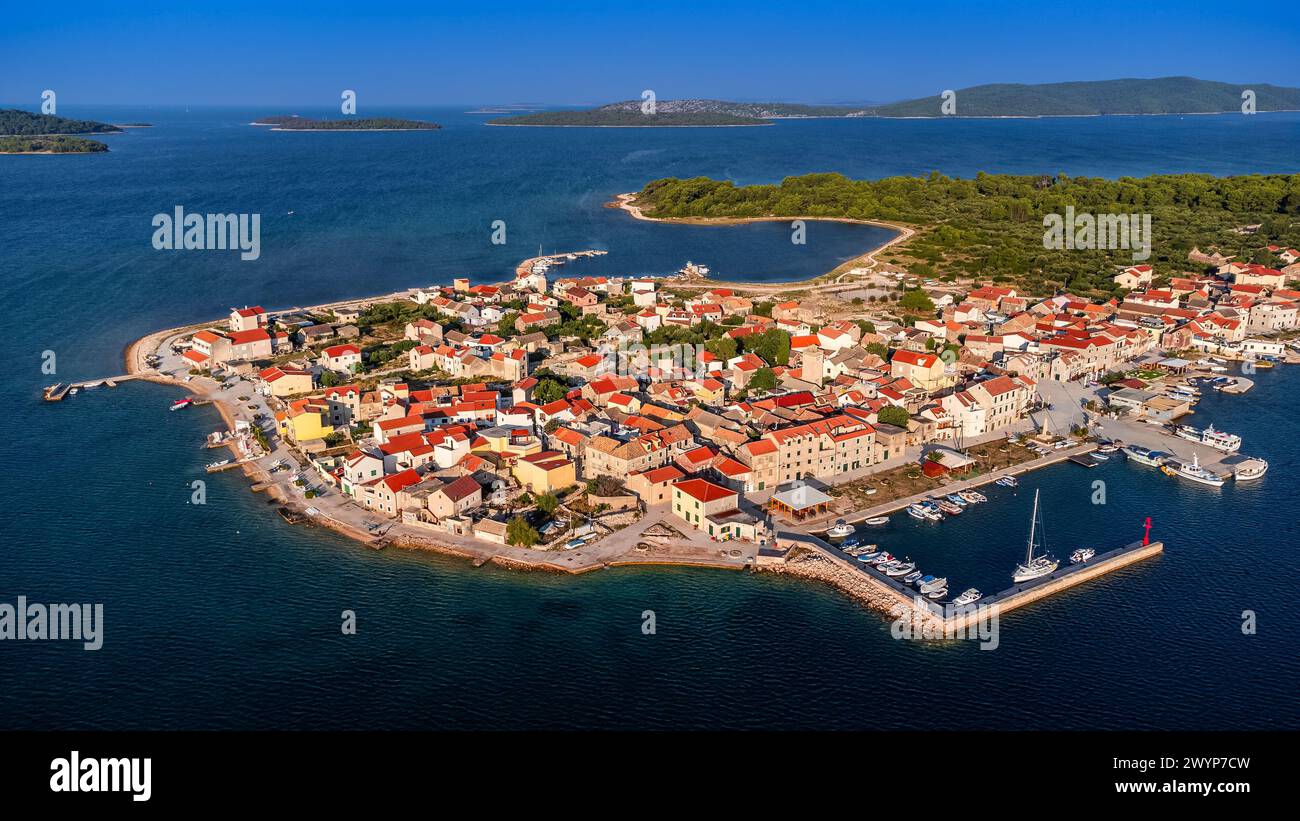 Krapanj, Kroatien - aus der Vogelperspektive auf die Insel Krapanj (Otok Krapanj), die kleinste bewohnte Insel Kroatiens. Yachten, rote Dächer und klarer blauer Himmel Stockfoto