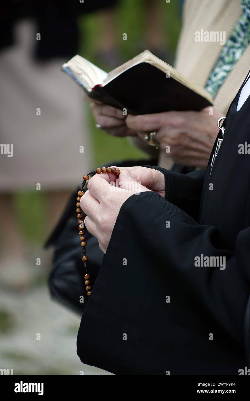Hände einer Frau, die während des Gebets einen Rosenkranz hält, christliche tägliche Verehrung eines Anbeters Gottes des Erlösers, Basilika der Himmelfahrt der Jungfrau Mar Stockfoto