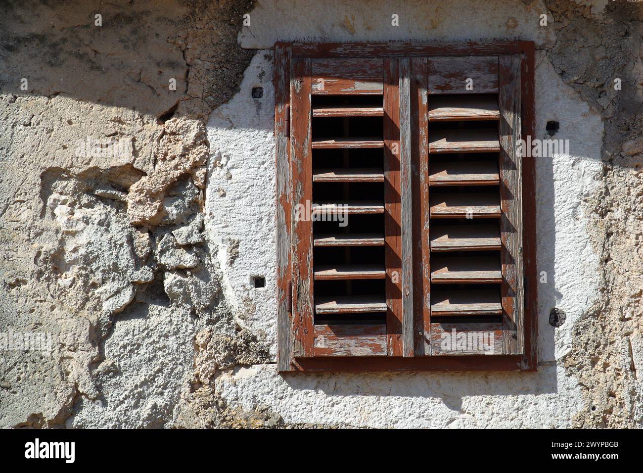 Fenster mit geschlossenen Holzläden in einem alten verlassenen traditionellen Haus in LUN, Insel Pag, Kroatien Stockfoto