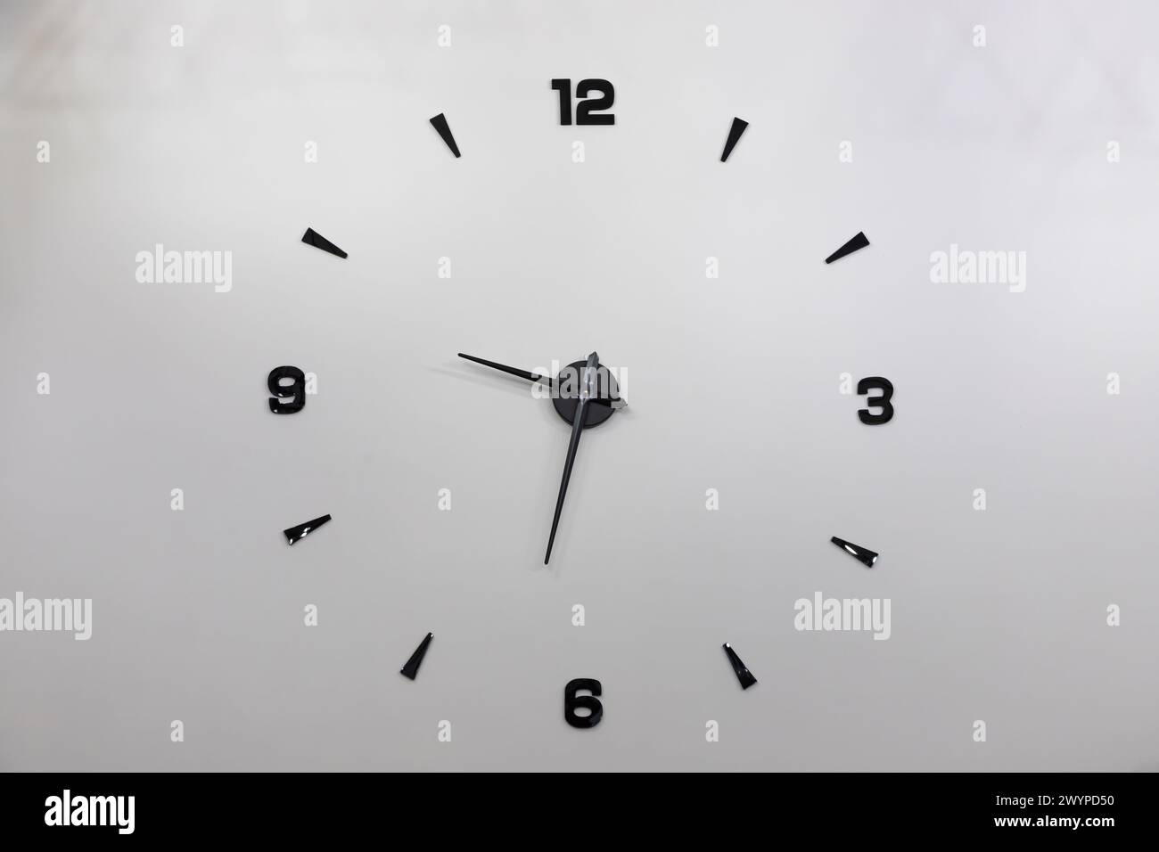 Minimalistisches Design einer Wanduhr mit schwarzen Zahlen. Stockfoto