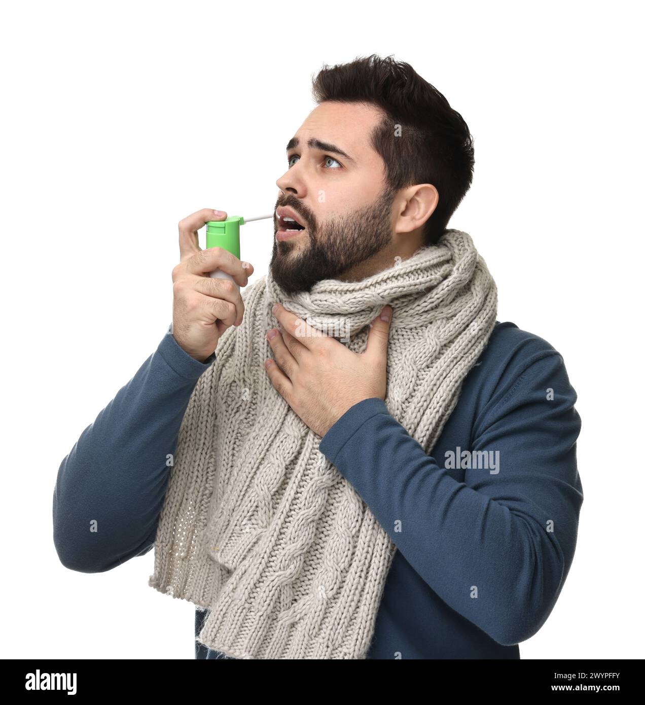Junger Mann mit Schal mit Kehlspray auf weißem Hintergrund Stockfoto