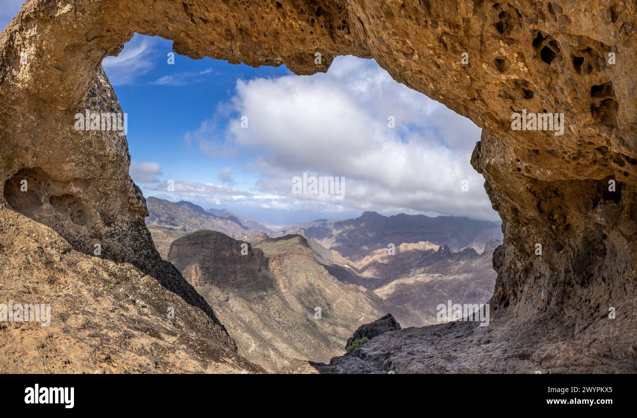 Blick durch die Felsformation Ventana del Bentayga (Fenster nach Bentayga) im Westen auf die Berglandschaft der zentralen Kanarischen Insel. Stockfoto