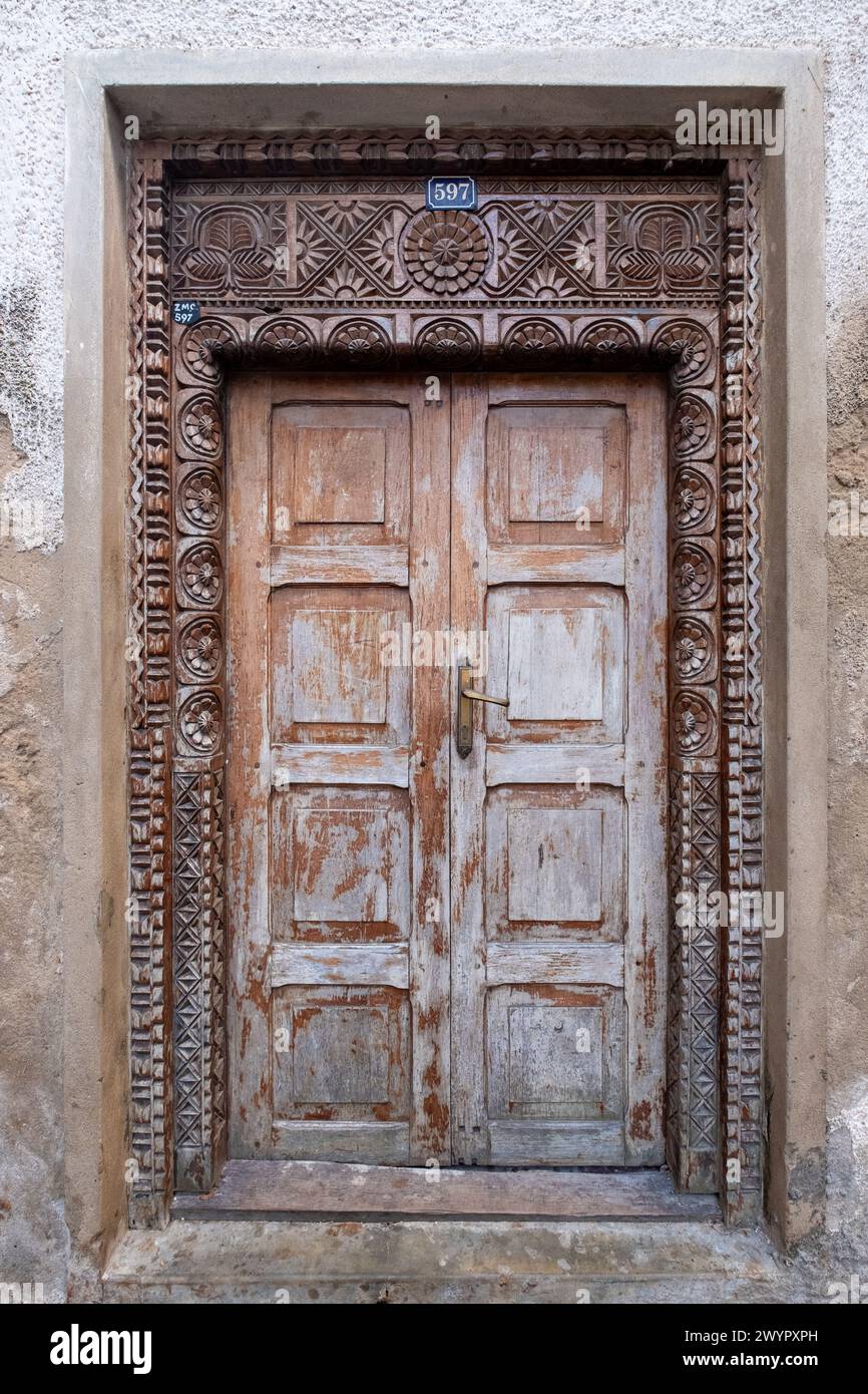 Ein aufwändig geschnitzter hölzerner Türrahmen am Eingang zu einem traditionellen arabischen Haus. Stockfoto