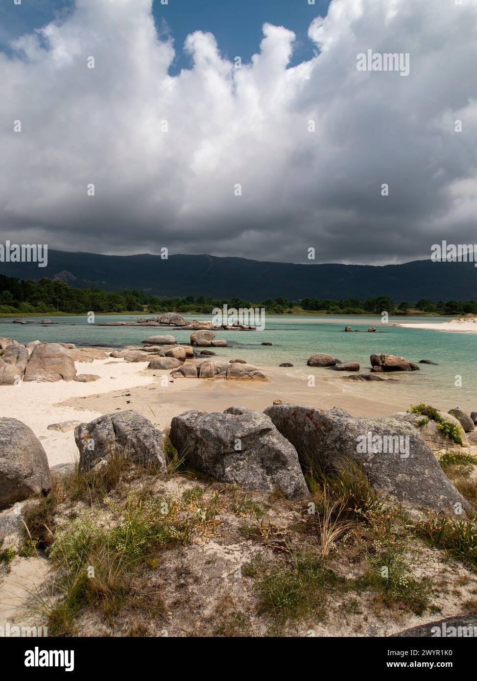 Küstenlandschaft. Meer, Felsen, Sand, Wolken und der Berg im Hintergrund. Strand Boca de Río, Carnota (Spanien) Stockfoto