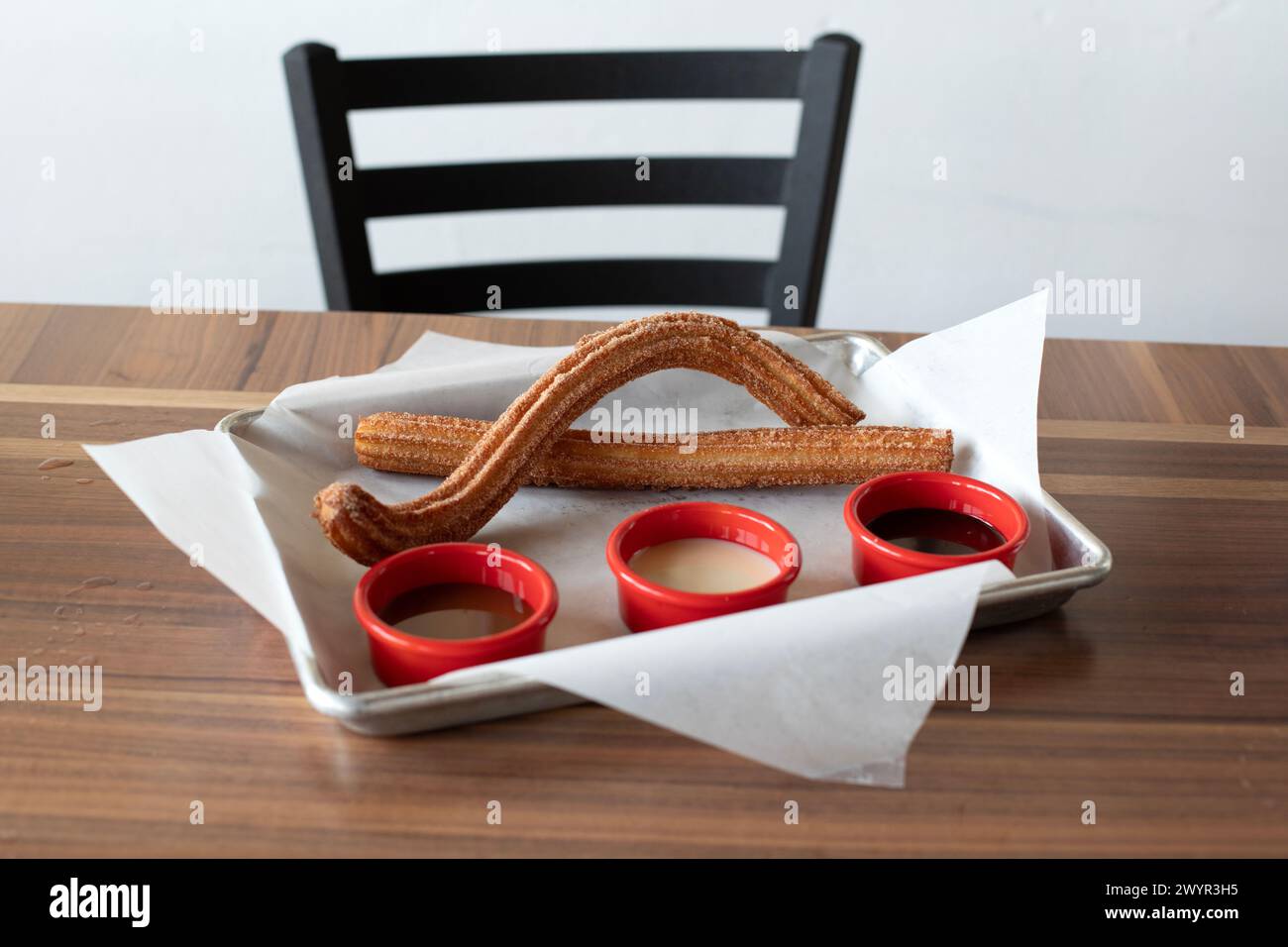 Churros auf einer Platte mit eingetauchten Saucen Stockfoto