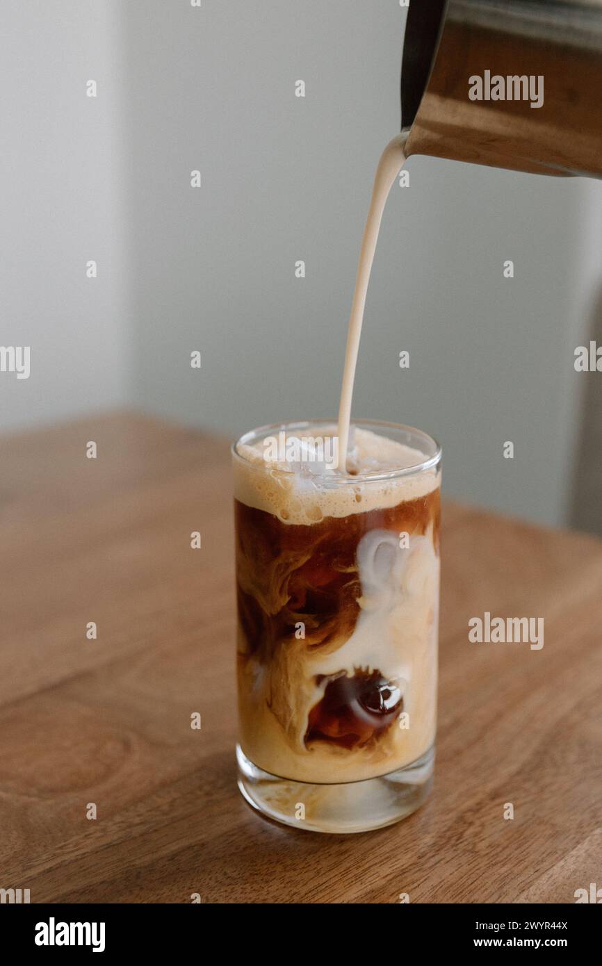 Sahne in Eiskaffee gießen Stockfoto