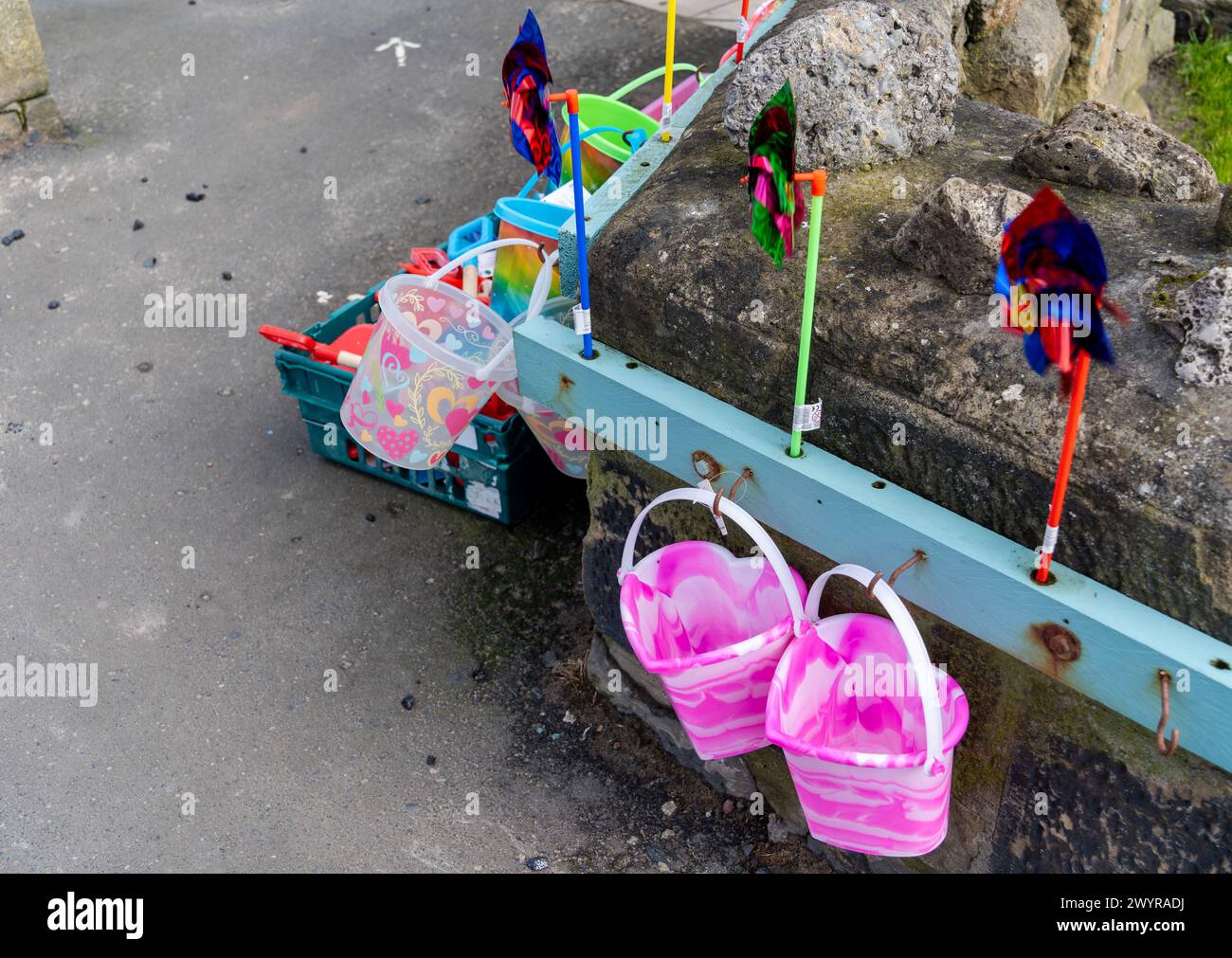 Eimer und Spaten und Spielzeugwindmühlen - Spielzeug wird an einem Kiosk am Meer angeboten Stockfoto