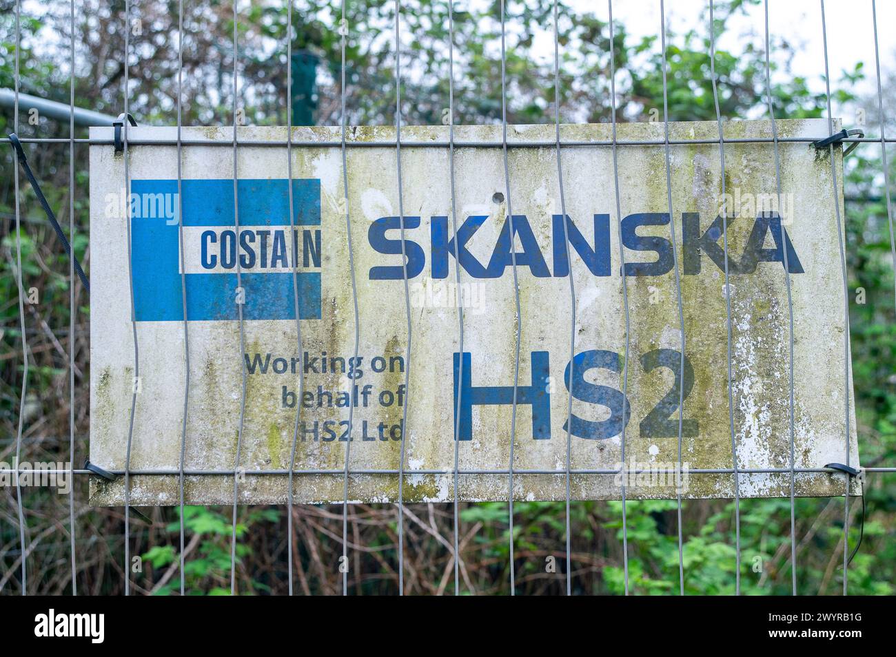 Harefield, Großbritannien. April 2024. Ein Costain Skanska HS2-Schild am Zaun einer HS2-Baustelle in Harefield, in der Nähe der Stelle, wo Wasser über eine Landstraße in Harefield fließt. HS2 hat Felder ausgegraben, zahlreiche Bäume gefällt und Hecken zerstört. Die Wasserstraßen, an denen HS2 arbeitet, müssen neue Routen finden, von denen die Einheimischen glauben, dass sie die Überschwemmungen in West London und den Chilterns verschärfen. Quelle: Maureen McLean/Alamy Live News Stockfoto