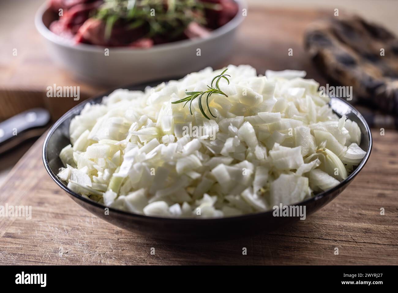 Schüssel mit geschnittenen weißen Bio-Zwiebeln auf hölzernem Hintergrund. Stockfoto