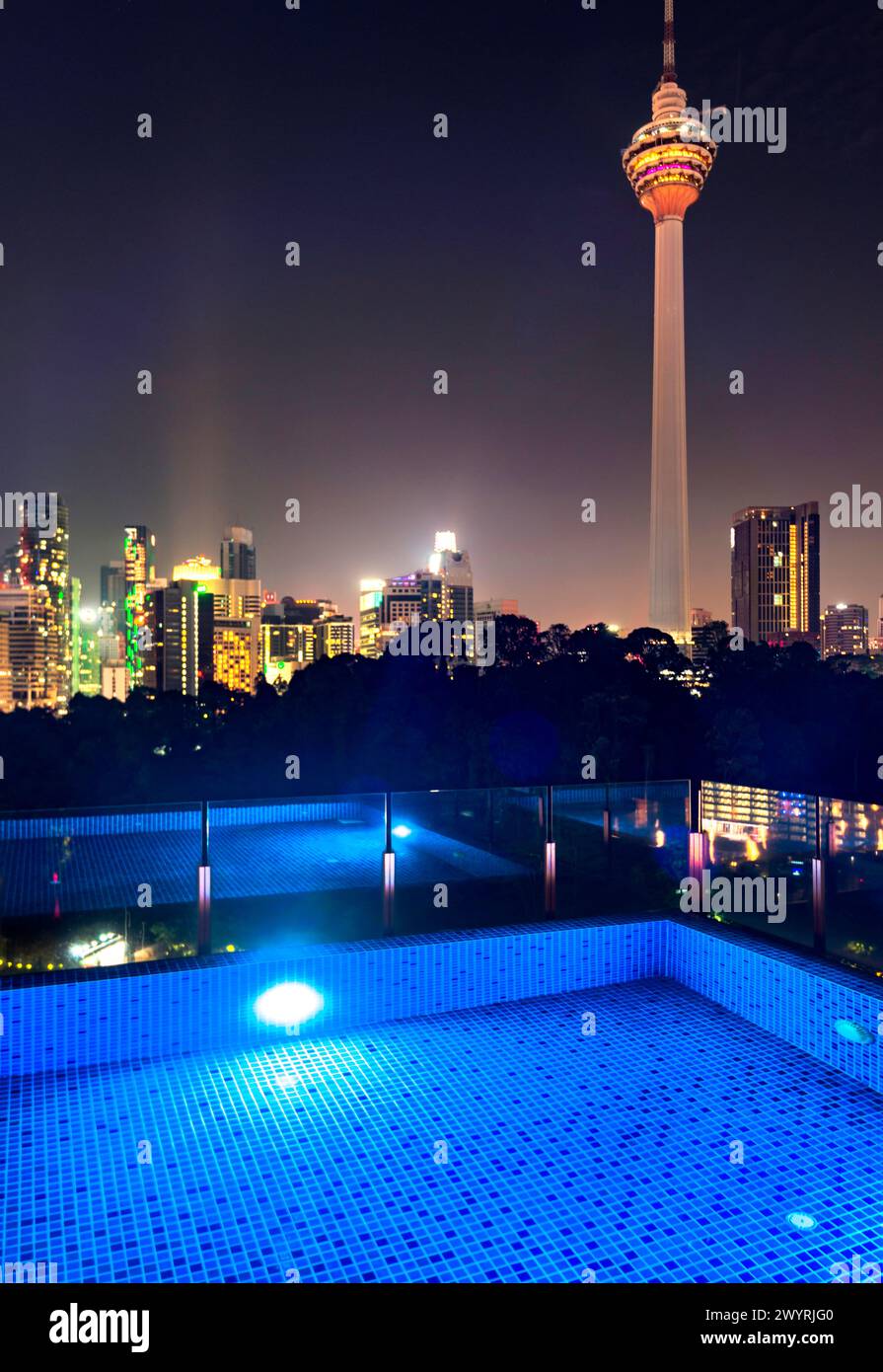 Atemberaubender Blick auf die Wolkenkratzer der Stadt KL, nachts hell beleuchtet, eleganter Pool im Vordergrund mit atemberaubendem Panoramablick Stockfoto