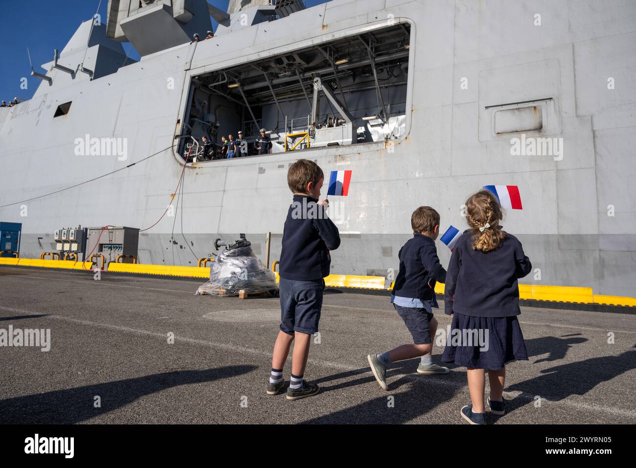 Toulon, Frankreich. April 2024. Kinder warten auf ihre Seeleute an Bord der Multimission Fregatte mit erweiterten Fähigkeiten (FREMM-da) Elsass in Toulon. Die französische Fregatte Elsass kehrte nach einer dreimonatigen Mission im Roten Meer und im Indischen Ozean zurück, um Handelsschiffe gegen Angriffe von Houti-Rebellen zu verteidigen. FREMM-da Credit: SOPA Images Limited/Alamy Live News Stockfoto