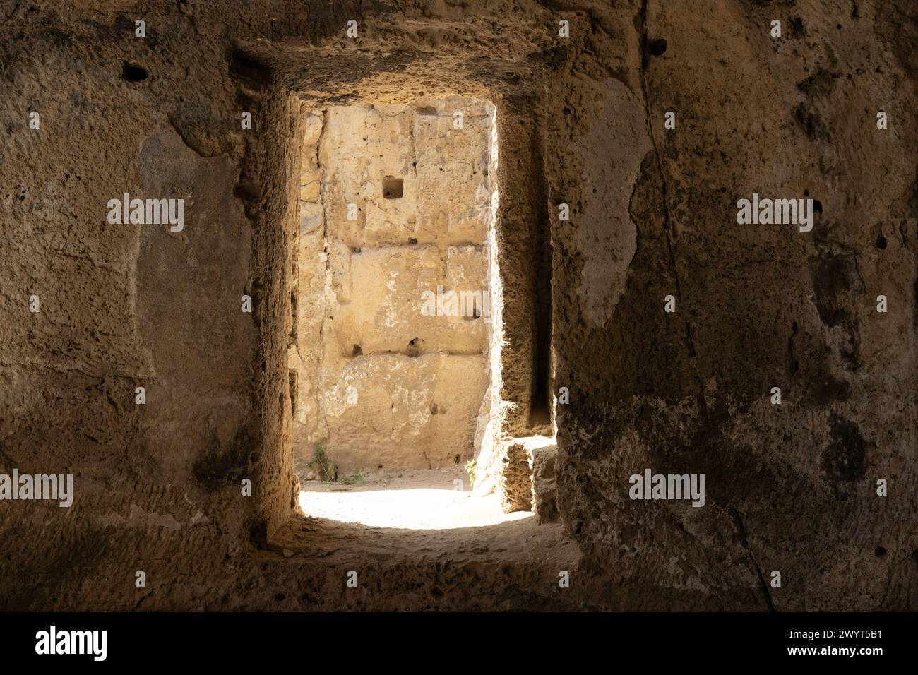 Blick durch den schattigen Eingang einer antiken Höhle im Paphos Archäologischen Park. Stockfoto