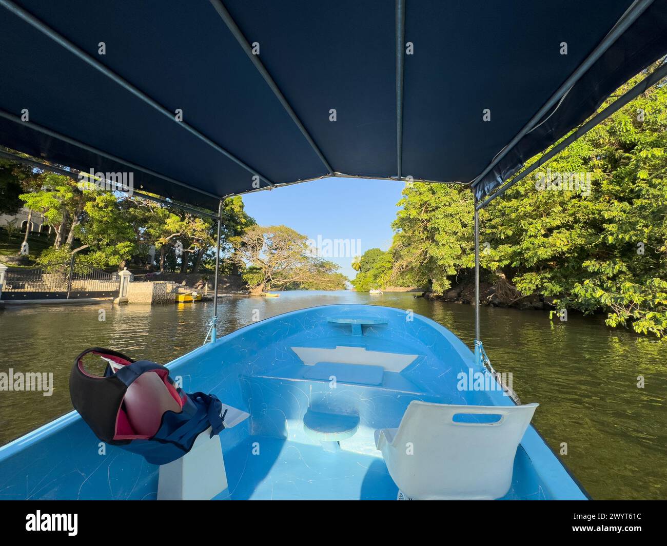 Bootsfahrt im Flusskanal mit grünem tropischem Hintergrund Stockfoto