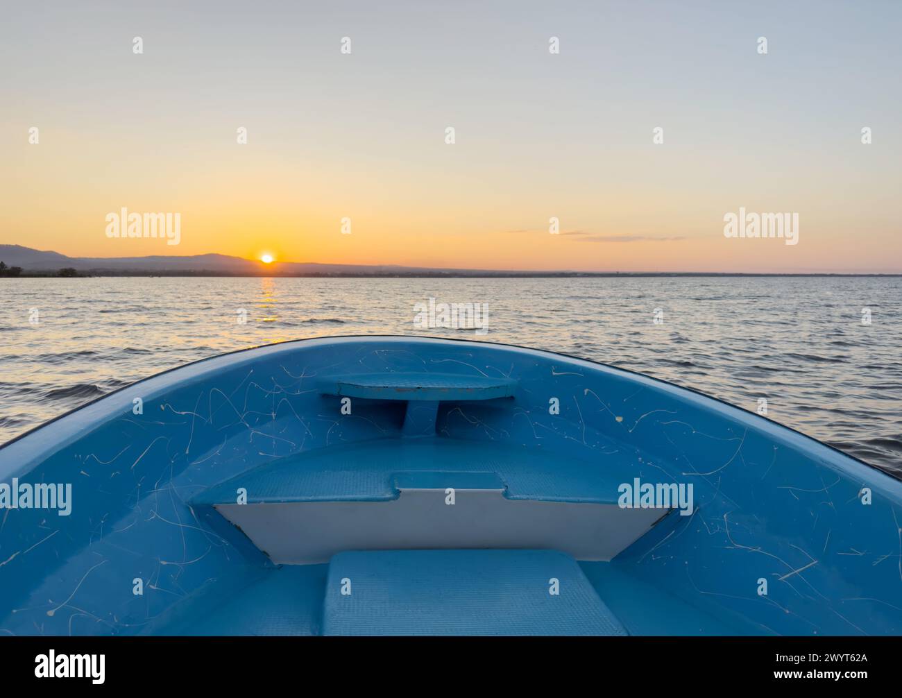 Blauer Bootsbogen auf Hintergrund des Sonnenuntergangs in orangefarbener Farbe Stockfoto