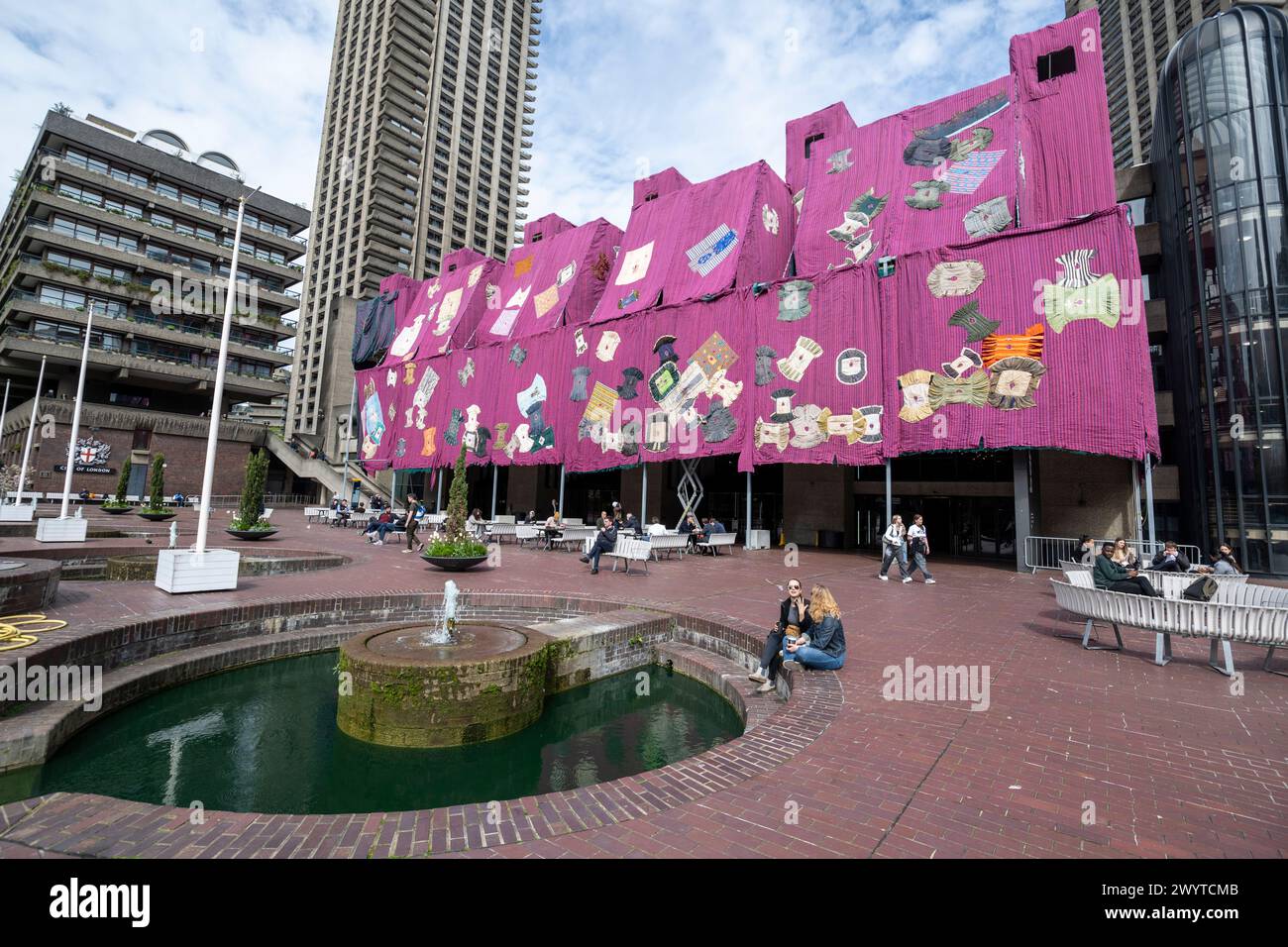 London, Großbritannien. 8. April 2024. „Purple Hibiscus“, 2023-24, des ghanaischen Künstlers Ibrahim Mahama, ist außen am Barbican angebracht. Die standortspezifische Installation wurde von Shanay Jhaveri, dem Leiter der Bildenden Künste des Barbican, in Auftrag gegeben und besteht aus 2000 m2 handgefertigtem rosa und lila gewebtem Tuch mit einem Gewicht von 20 Tonnen. Bei näherem Hinsehen werden 100 traditionelle Gewänder, Batakaris genannt, die von den ghanischen Königen getragen wurden. Das Kunstwerk fällt mit der laufenden Ausstellung des Barbican „Unravel: The Power and Politics of Textiles in Art“ zusammen. Quelle: Stephen Chung / Alamy Live News Stockfoto