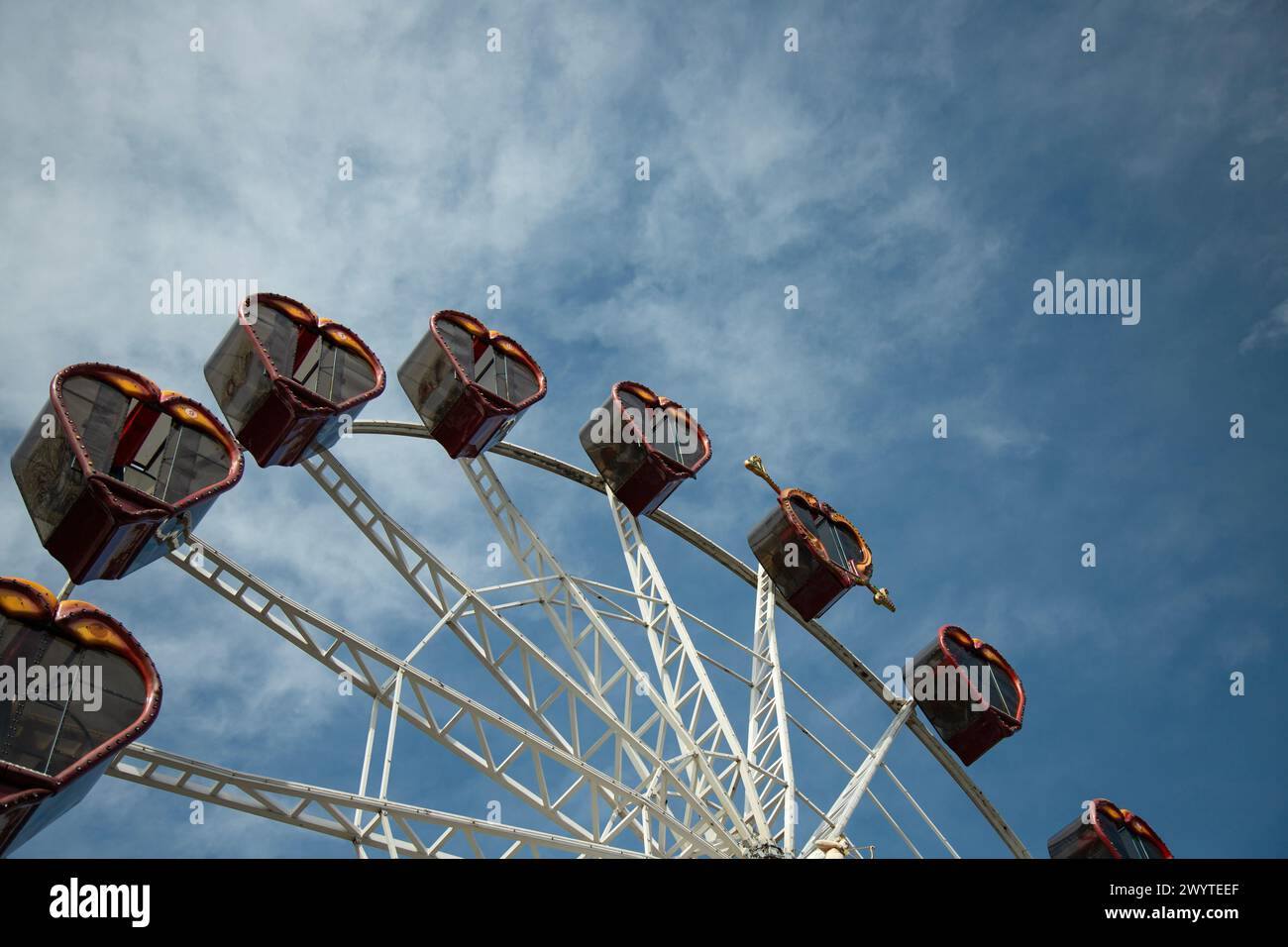 Riesenrad auf blauem Himmel Hintergrund, mit Metallbalkenführungen und Fahrgastkabinen. Stockfoto