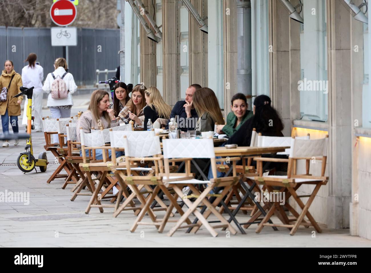 Leute, die sich unterhalten, während sie auf der Terrasse des Straßencafés sitzen. Leben und Freizeit in der Frühlingsstadt Stockfoto