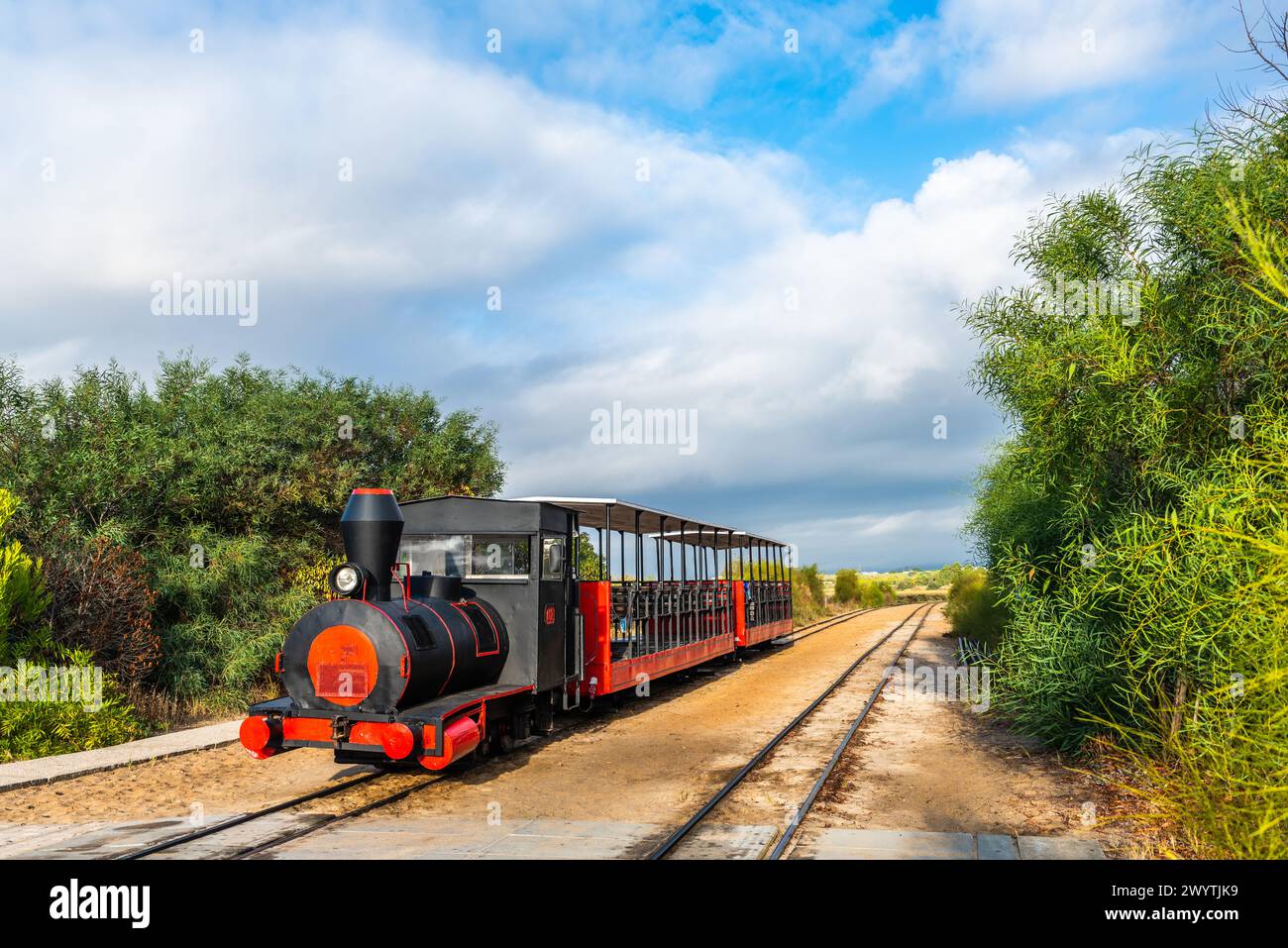 Der Retro-Zug bringt Besucher vom Festland zum Strand Barril in der Nähe von Tavira, Portugal. Stockfoto