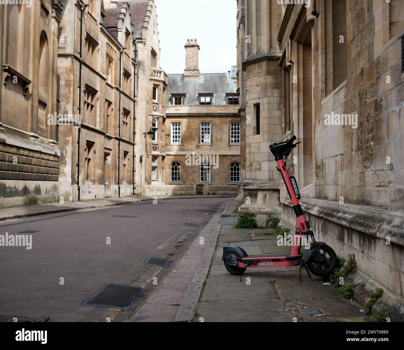 Moderne Motorroller, die auf einer alten Straße in der Nähe der Universität in Cambridge, Großbritannien, geparkt werden. Stockfoto