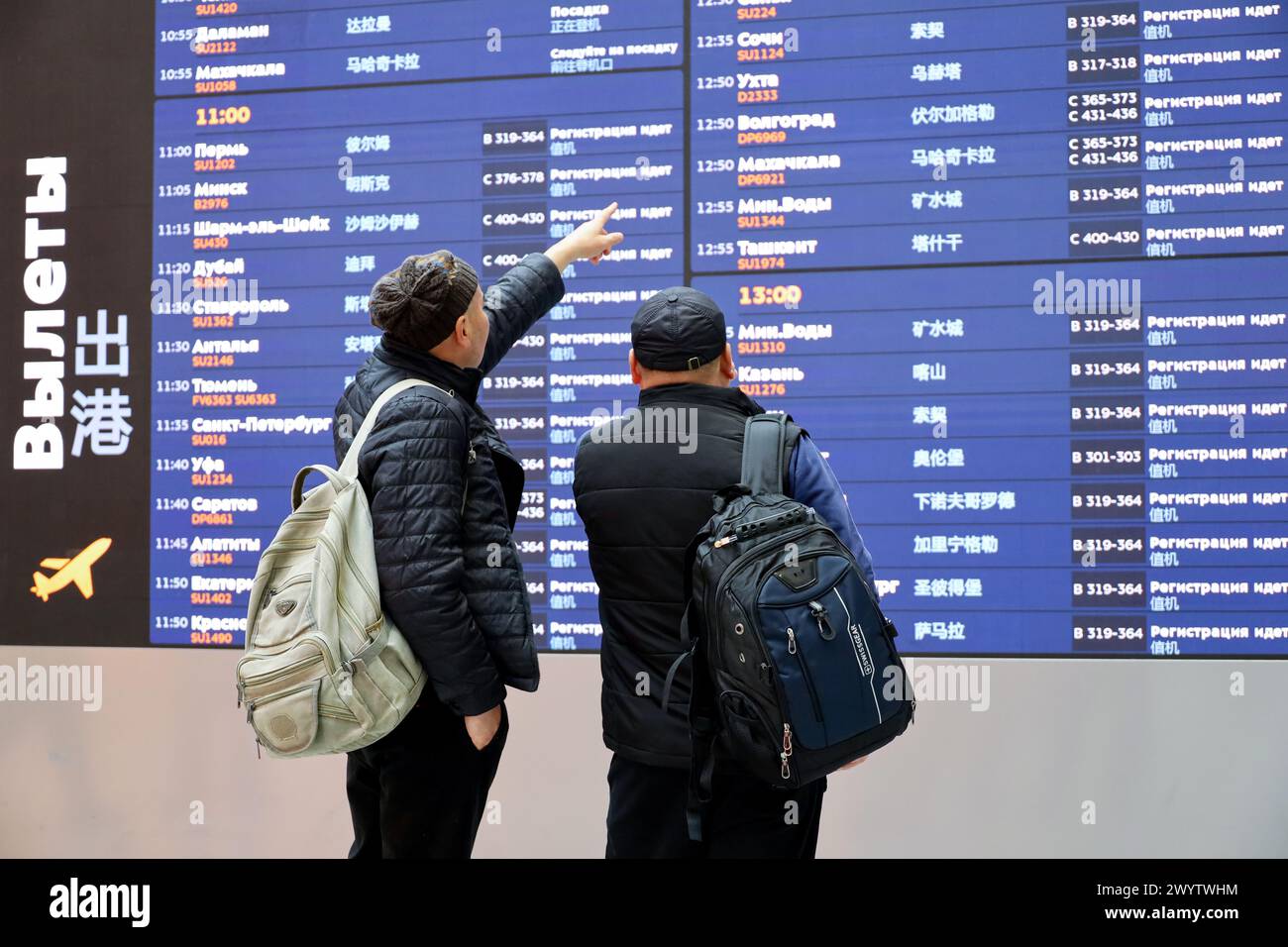 Passagiere mit Blick auf den Abflugtisch im Terminal B des Flughafens Sheremetjewo in Moskau Stockfoto