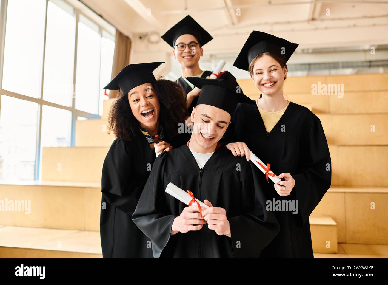 Eine Gruppe von Studenten in Abschlusskleidern und -Mützen posiert glücklich für ein Foto, um ihre akademische Leistung zu feiern. Stockfoto