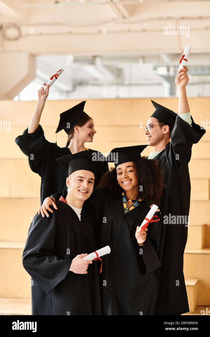 Verschiedene Gruppen von Studenten in Abschlusskleidern und -Mützen posieren glücklich für ein Foto. Stockfoto