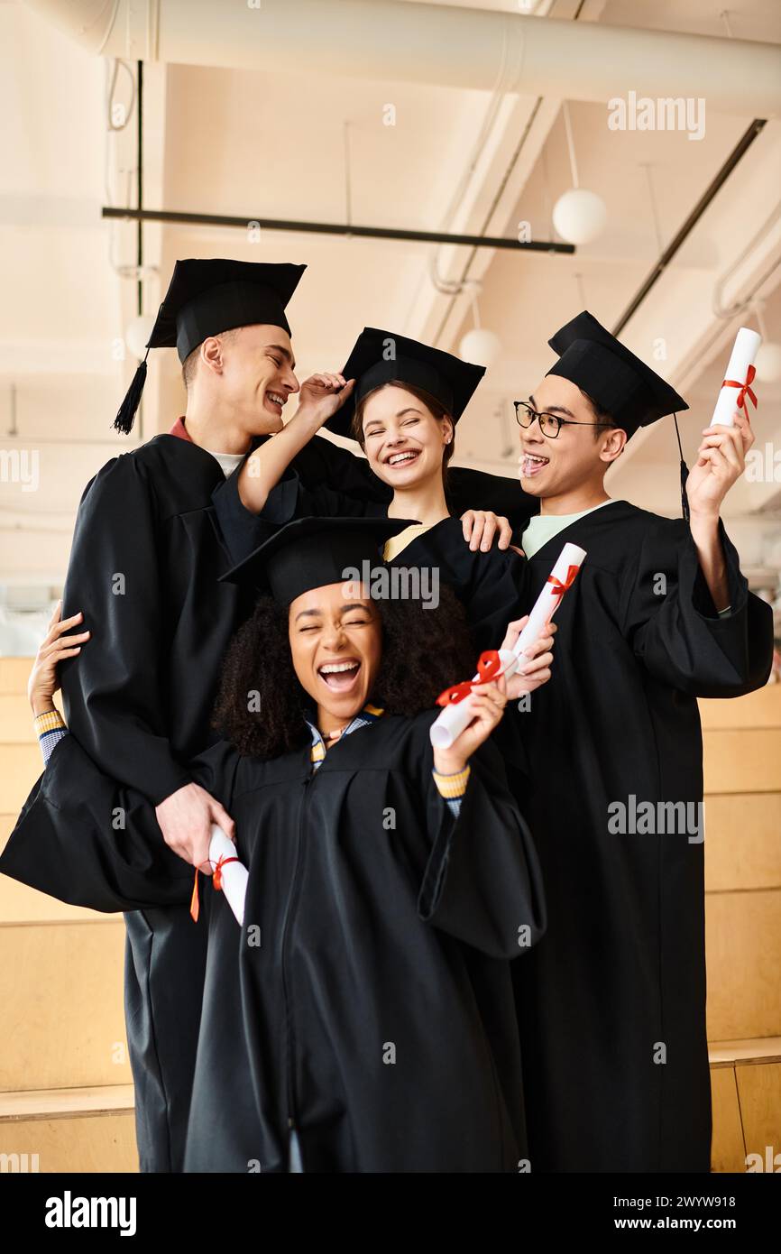 Eine Gruppe multikultureller Studenten in Abschlusskleidern, die ihren akademischen Erfolg feiern, während sie für ein Foto posieren. Stockfoto