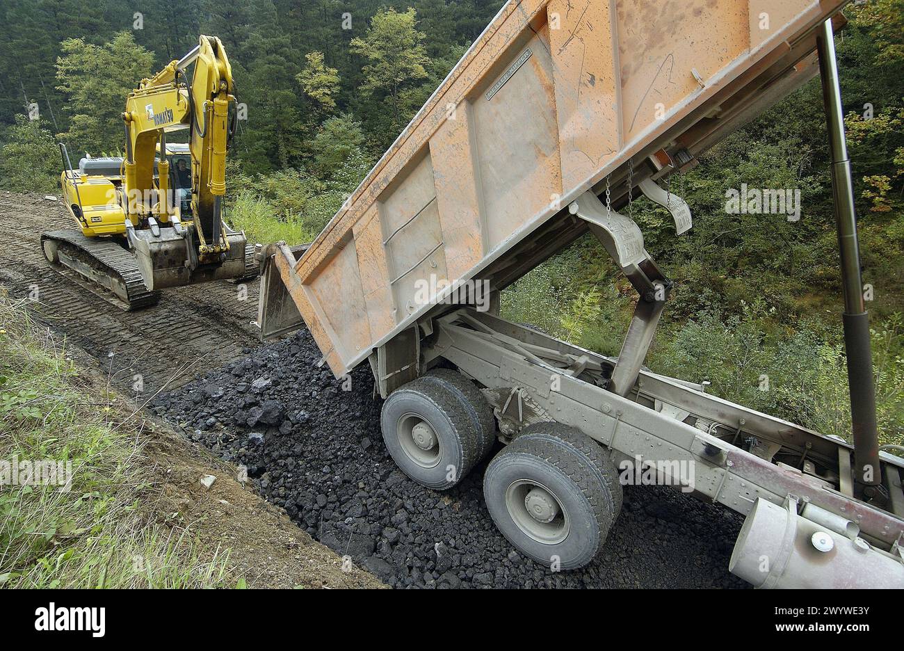 Bau eines Waldweges mit schwarzer Schlacke aus der Gießerei. Ormaiztegi, Guipúzcoa. Euskadi, Spanien. Stockfoto