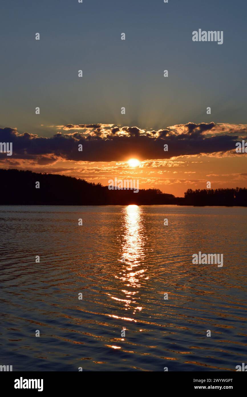 Wunderschöner Sonnenuntergang über dem See. Reflexion der Sonne im Wasser. Abends. Stockfoto