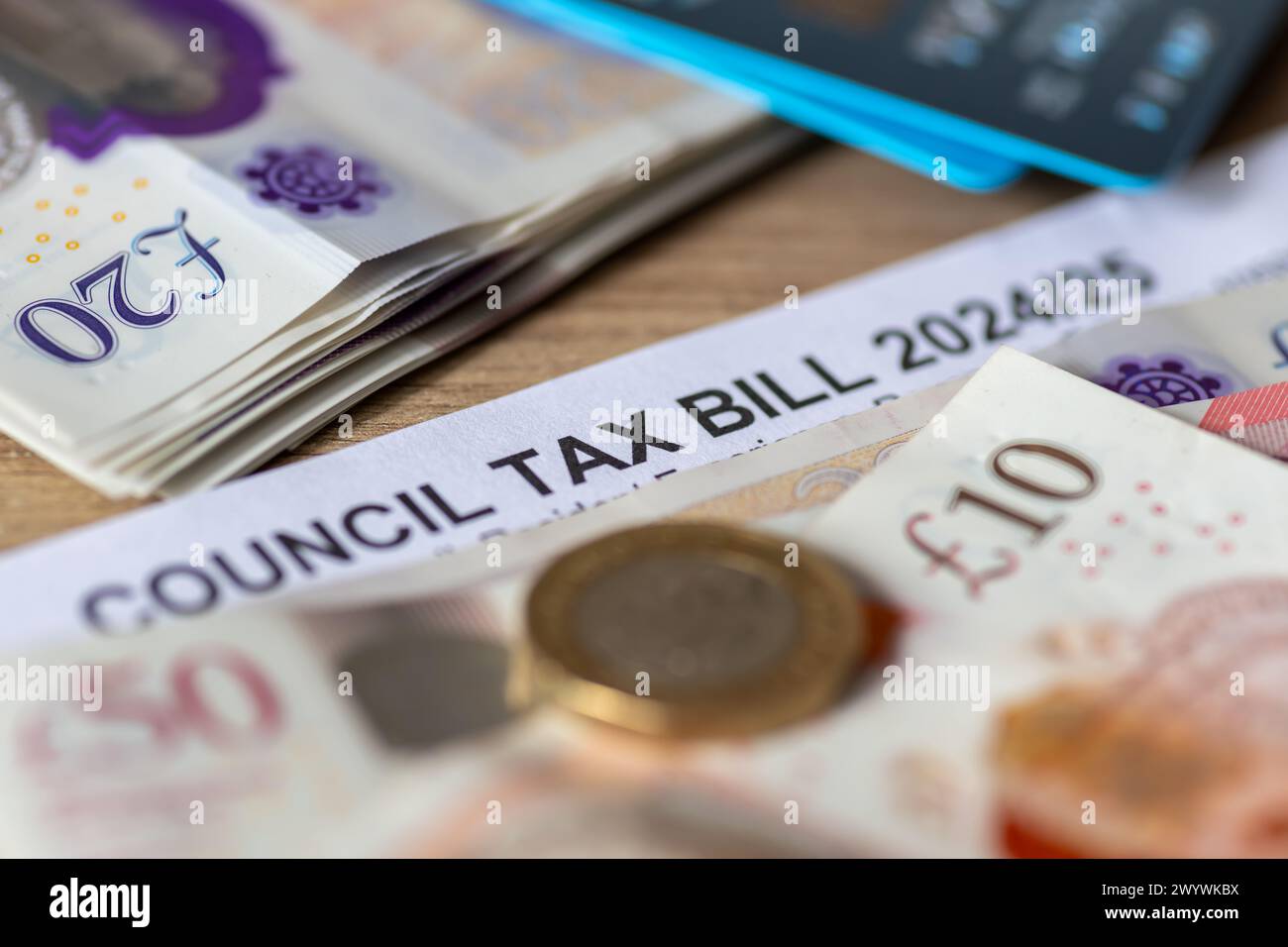 Eine Nahaufnahme eines Steuergesetzes der britischen Behörden mit Banknoten, Pound Coins und Bankkarten. Stockfoto