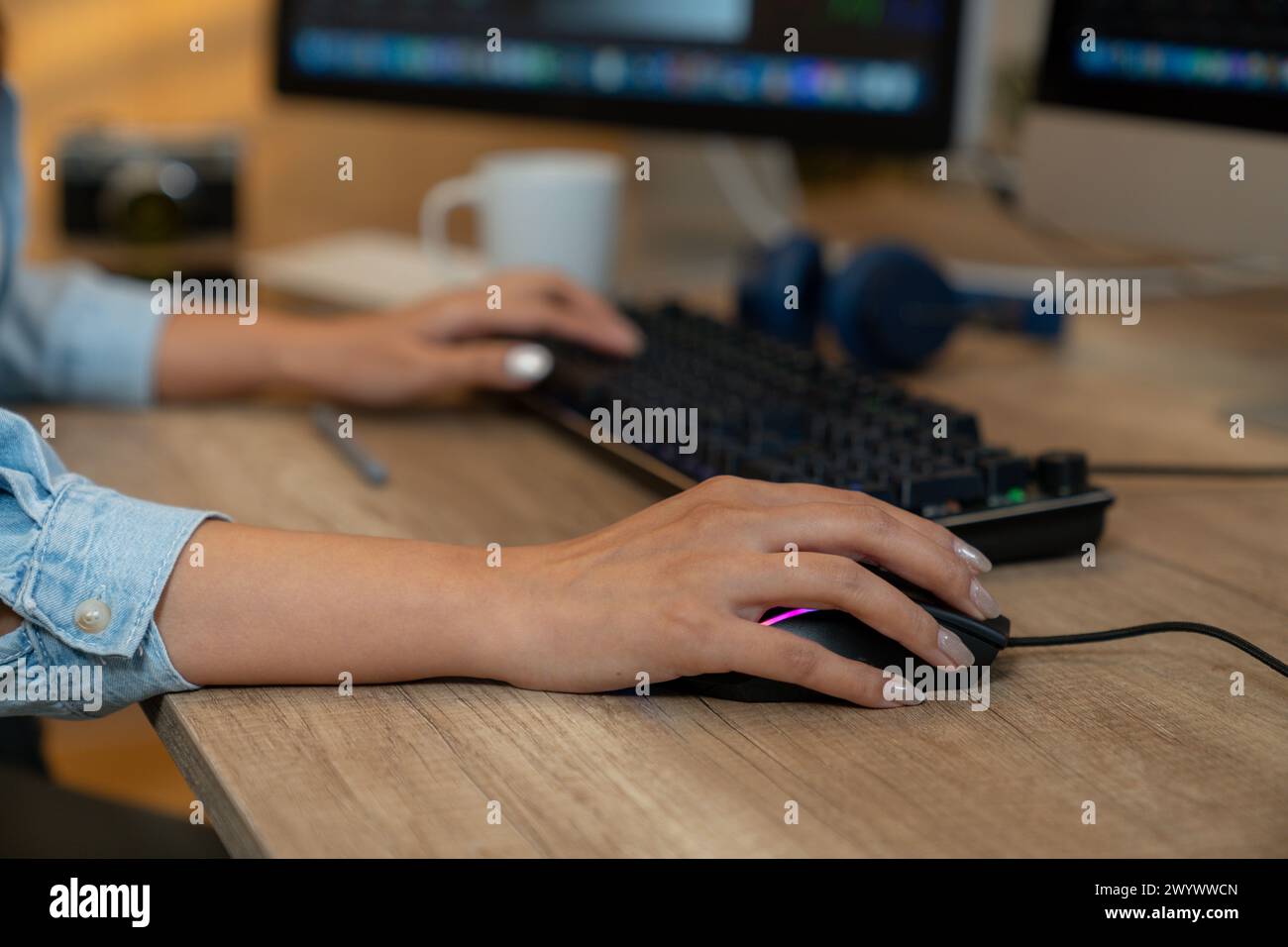 Die Hände der jungen Frau, die mit einem Maus- und Tastaturcomputer arbeitet Stockfoto