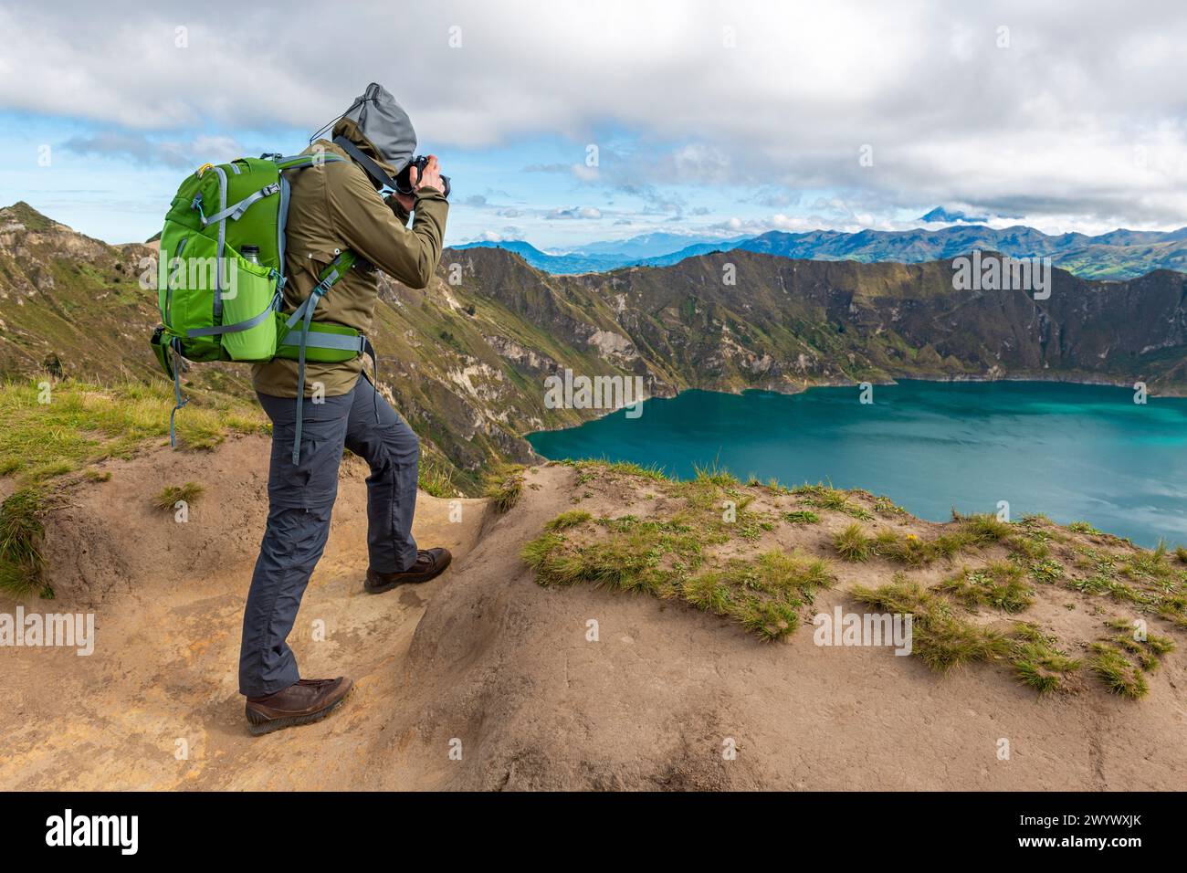 Fotograf im Trekking-Outfit fotografiert den Quilotoa-See entlang der Quilotoa-Loop-Wanderung, Anden, Quito, Ecuador. Stockfoto