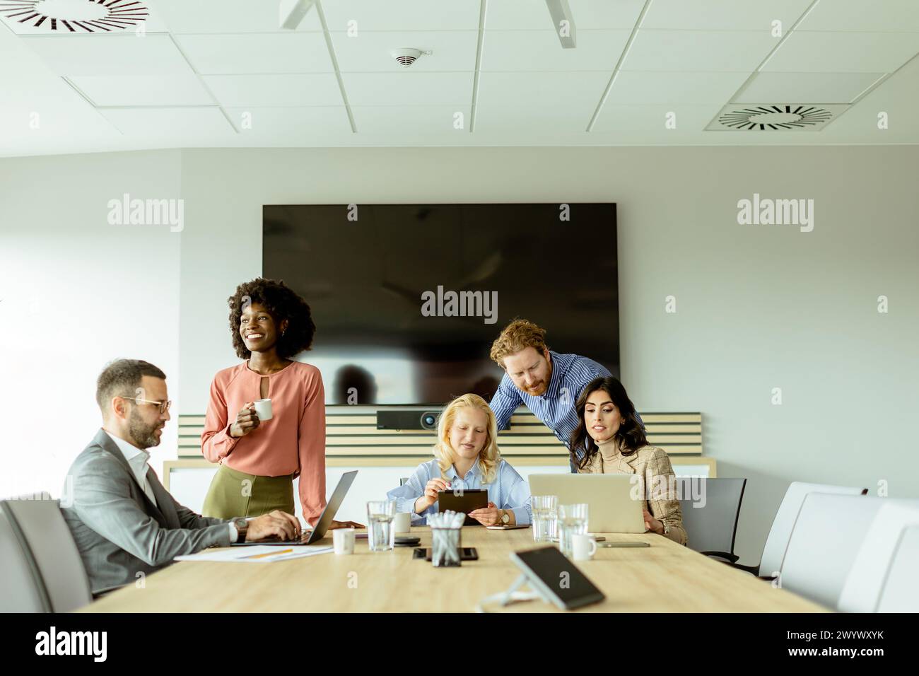 Multiethnische Gruppe von Fachleuten, die an einem Konferenztisch in einem hell beleuchteten Büro ein Brainstorming durchführen. Stockfoto