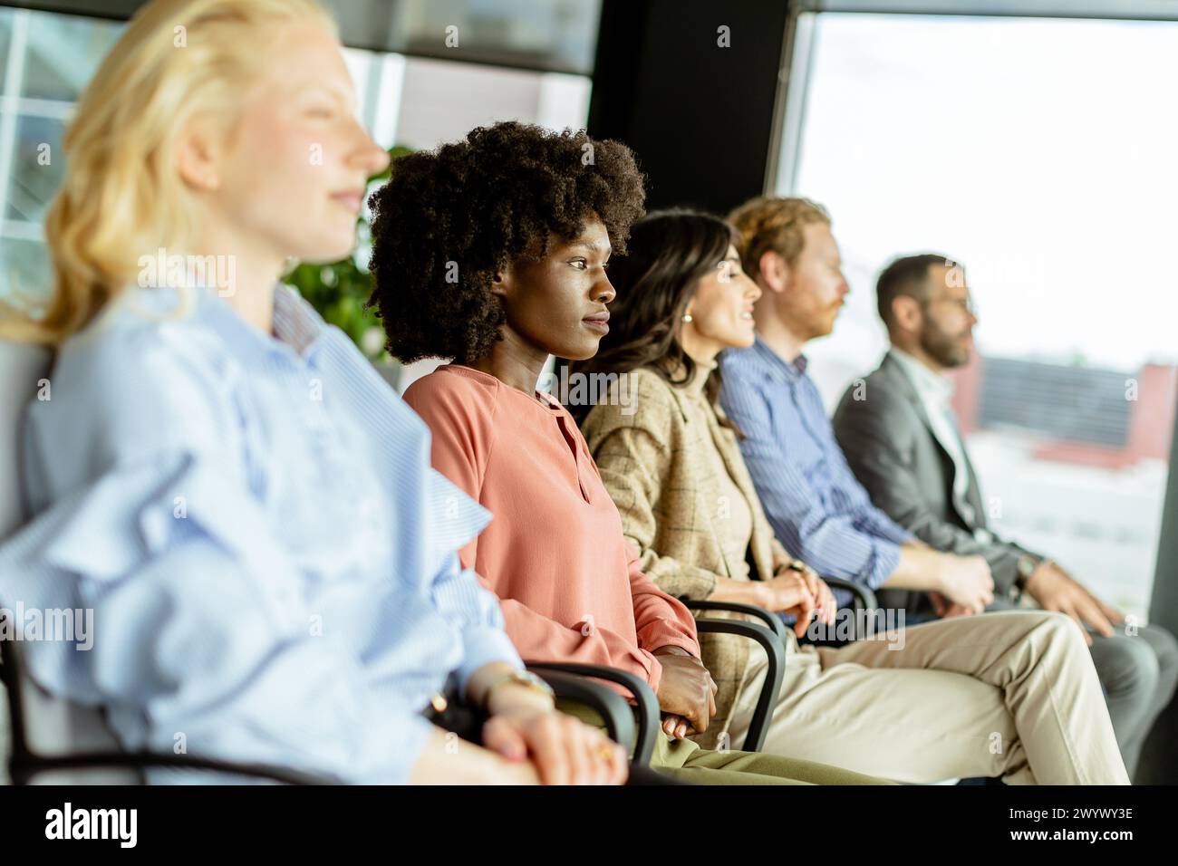 Die lächelnde Frau führt eine Runde Applaus mit Gleichaltrigen und teilt einen Moment der Freude Stockfoto