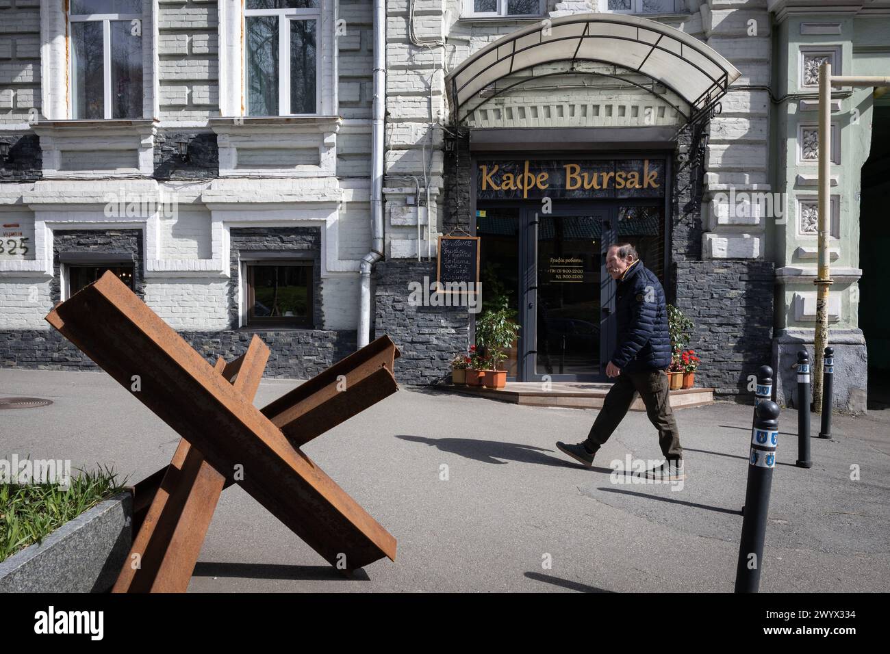 Kiew, Ukraine. April 2024. Ein Mann läuft in der Nähe eines Panzerabwehrigels auf einer Straße im Zentrum von Kiew. Die ukrainische Hauptstadt liegt abseits der Kampforte, aber die Anwesenheit des Krieges ist in der Stadt spürbar und beeinflusst viele Aspekte des Lebens der Einwohner. Russische Truppen drangen im Februar 2022 in ukrainisches Gebiet ein und begannen einen Konflikt, der die Zerstörung von Gebieten und humanitäre Krise provozierte. Quelle: SOPA Images Limited/Alamy Live News Stockfoto