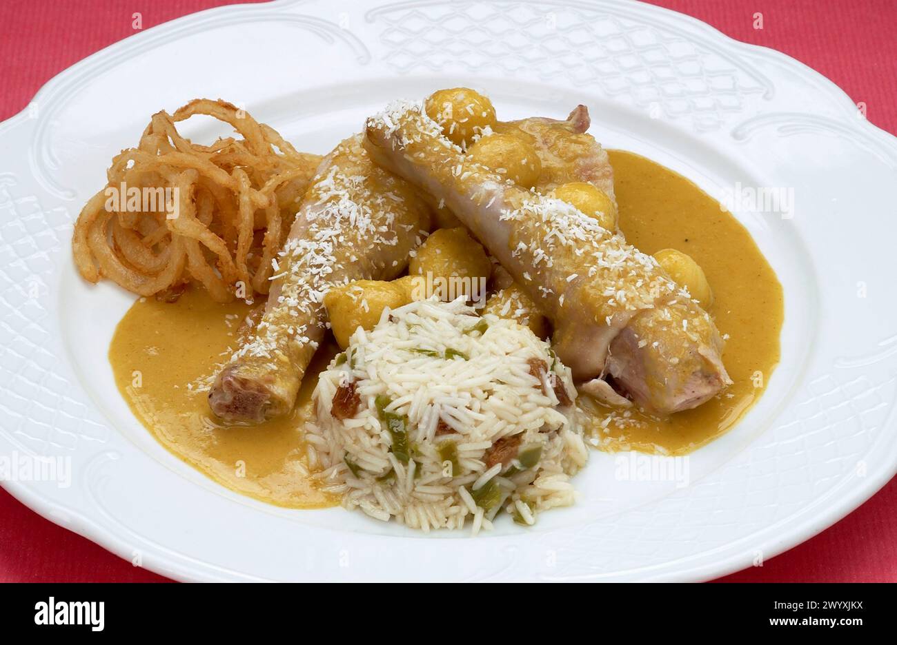 Pollo al Curry con Arroz Oriental (Pollo, Cebolla, Manzana Reineta, Salsa de Tomate, Coco Rallado, Curry, Vino blanco, Caldo de Ave, Harina, Aceite de oliva, Para el Arroz: Arroz Basmati, Piñones, Pasas, Pimiento verde, Cebolla, Caldo de Ave, Sal y Pimienta), Carnes, Escuela de Cocina Luis Irizar, Donostia, San Sebastián. Stockfoto