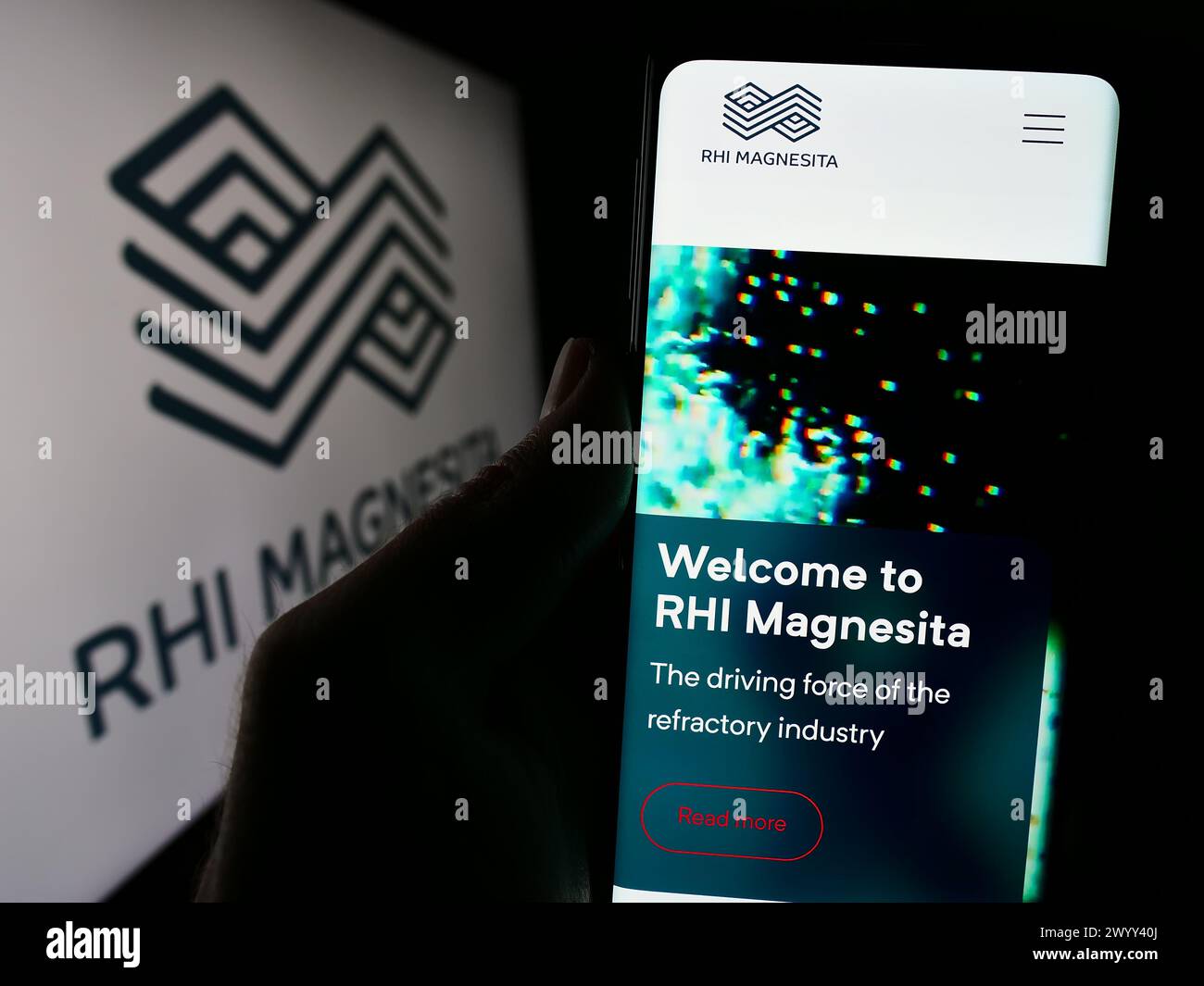 Person, die ein Handy hält und vor dem Logo die Webseite der Firma RHI Magnesita N.V. Konzentrieren Sie sich auf die Mitte des Telefondisplays. Stockfoto