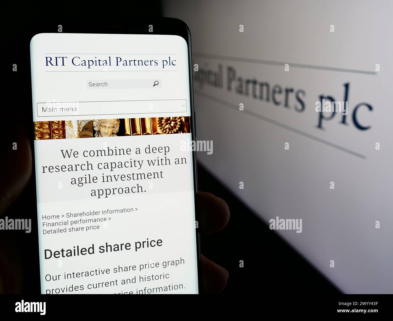 Person mit Smartphone und Webseite der britischen Investmentgesellschaft RIT Capital Partners plc vor dem Logo. Konzentrieren Sie sich auf die Mitte des Telefondisplays. Stockfoto