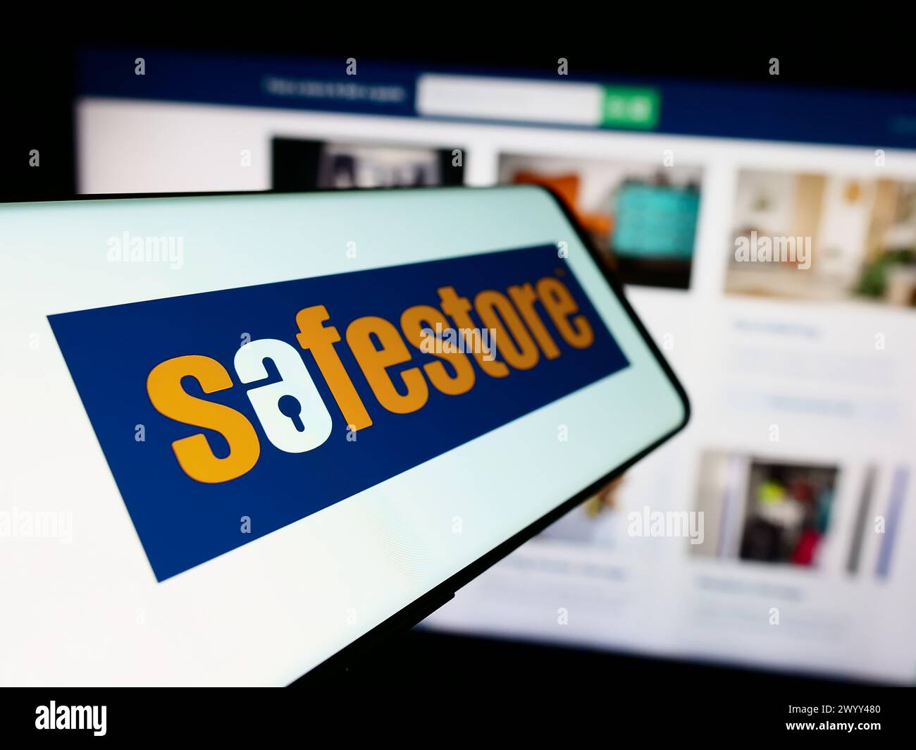 Handy mit Logo der britischen Selbstspeicherungsfirma Safestore Holdings plc vor der Business-Website. Fokus auf der linken Seite des Telefondisplays. Stockfoto