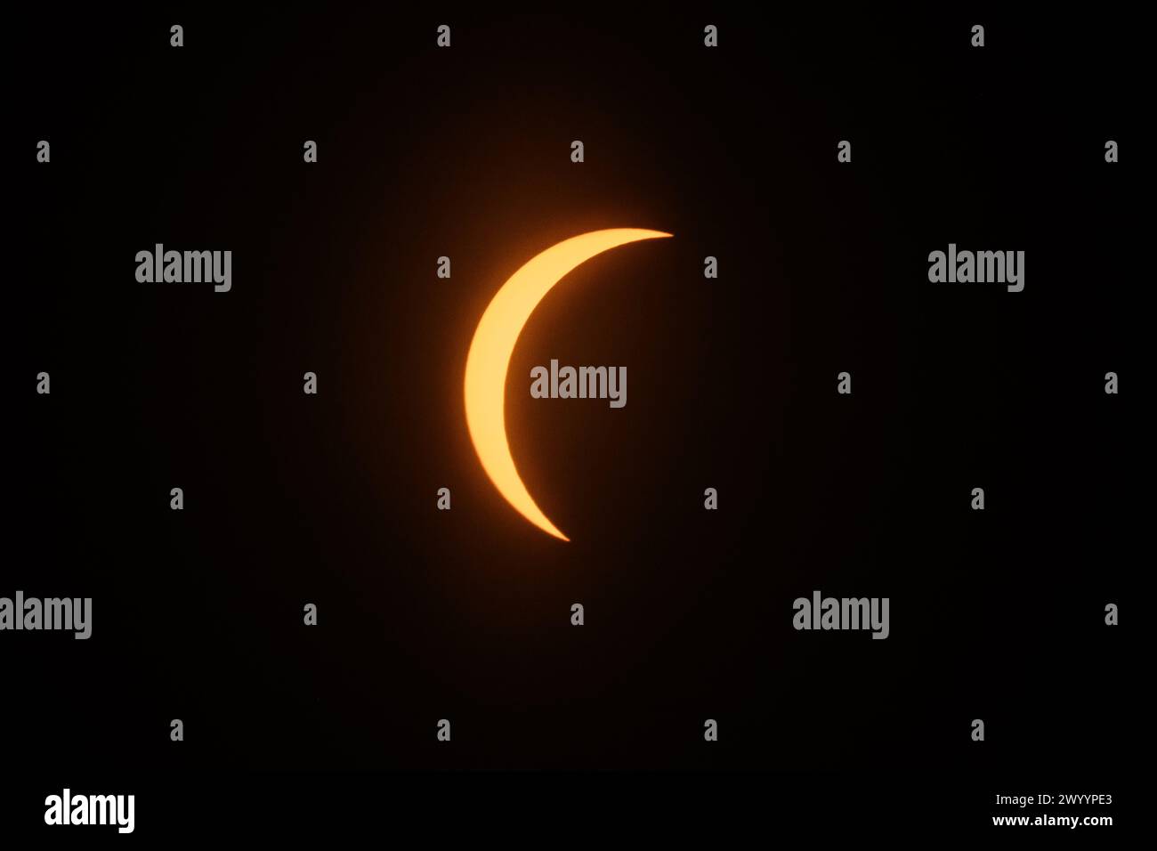 New York, USA. April 2024. Der Mond blockiert die Sonne teilweise während einer Sonnenfinsternis, die von der Aussichtsplattform im 86. Stock des Empire State Building in der Mitte des Nachmittags aus gesehen wird, wobei ein Schutzfilter über einer langen Teleobjektive verwendet wird. Credit: Alamy Live News/Enrique Shore Credit: Enrique Shore/Alamy Live News Stockfoto