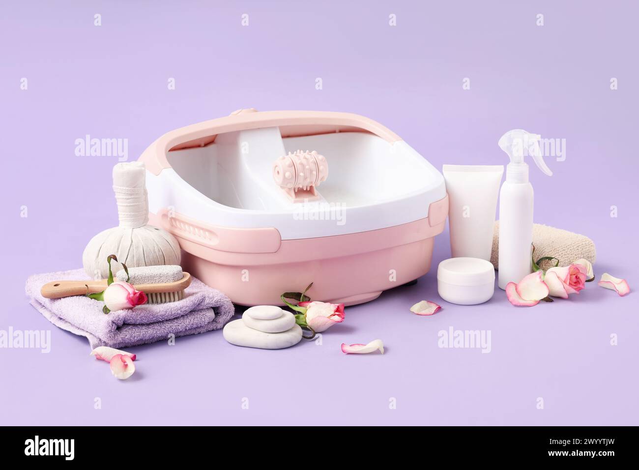 Set für Fußmassage auf violettem Hintergrund Stockfoto