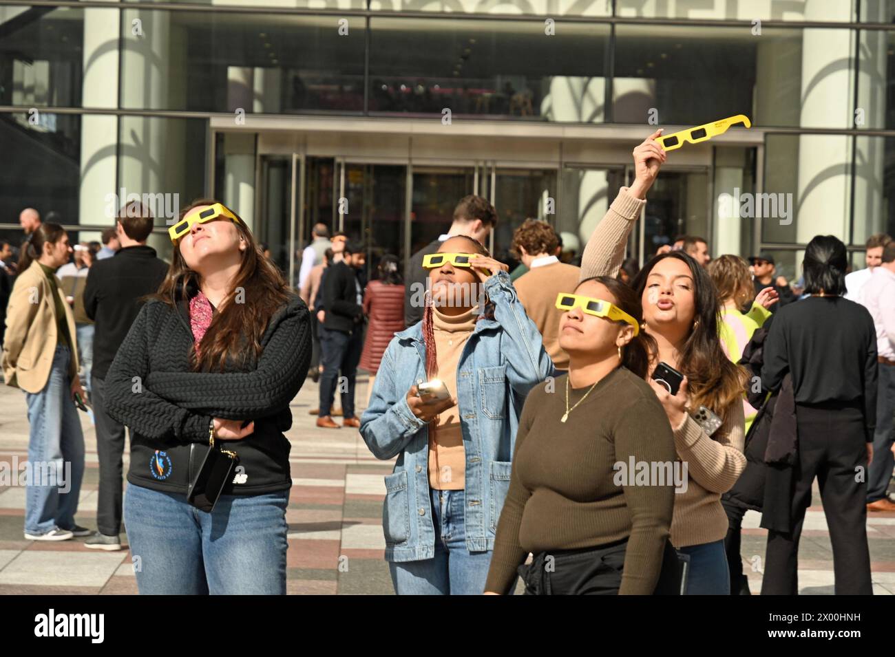 8. April 2024, %G: (NEU) die Sonnenfinsternis 2024 in New York City. April 2024, New York City, New York, USA. Die lang erwartete Sonnenfinsternis wird erscheinen, wenn der Mond die Sonnenstrahlen blockiert, während er zwischen Sonne und Erde vorbeizieht und einen Schatten auf die Erde wirft. Um 14:00 Uhr wurde die Sonnenfinsternis von einer großen Menge von Menschen jeden Alters begrüßt. Diese Menschenmenge erstreckte sich vom Winter Garden Atrium (wo ich stand) auf der Westseite von Manhattan, neben dem Hudson River, hinunter zur South Ferry. Die Sonnenfinsternis endete um 16:36 Uhr Eastern Time. Die nächste Sonnenfinsternis in New York wird im y sein Stockfoto