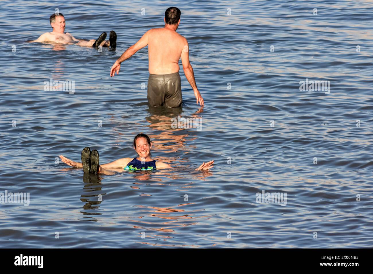 Eine Frau lächelt, während sie im Toten Meer in Israel schwimmt. Stockfoto
