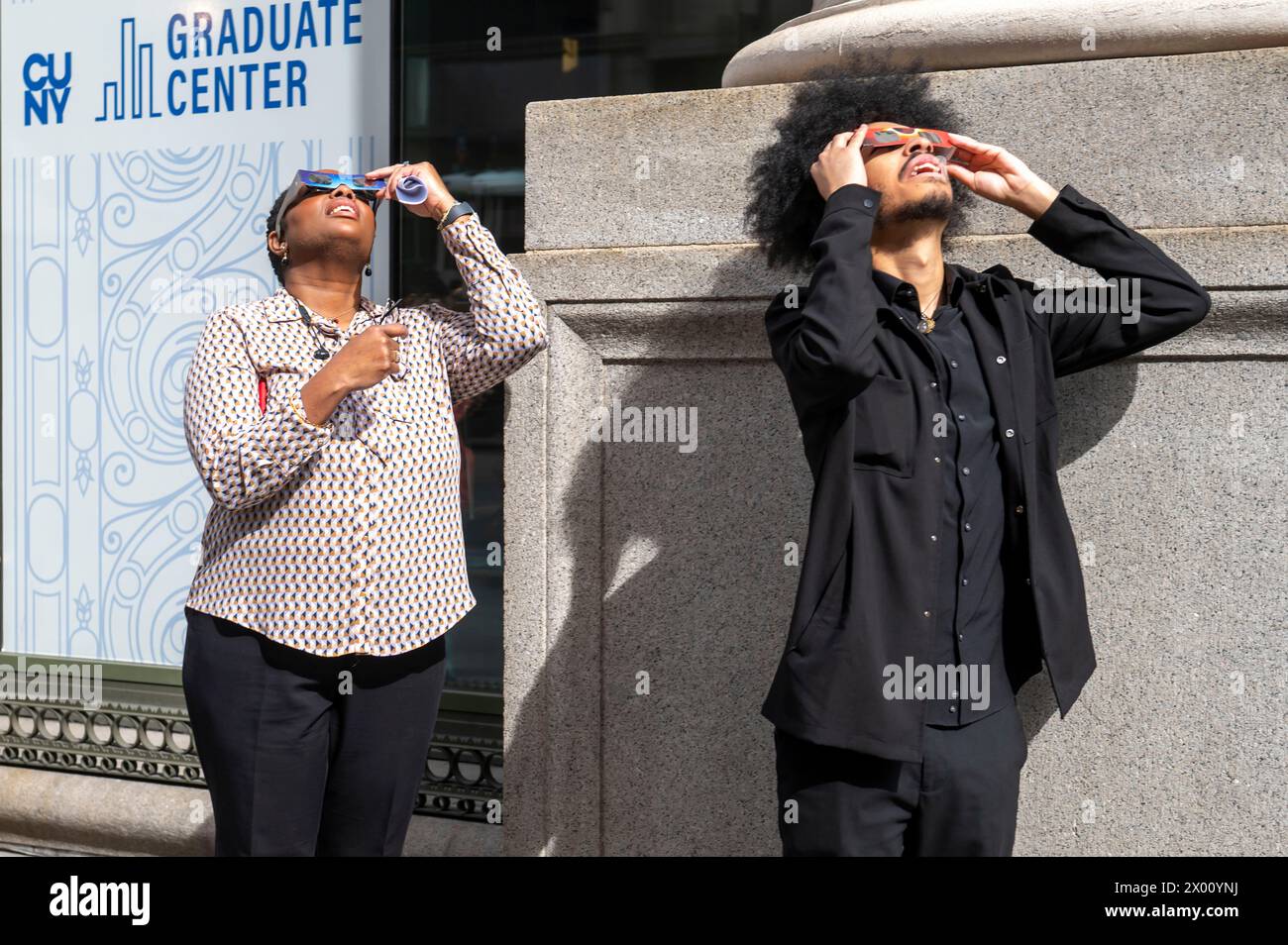 New York, Usa. April 2024. Die Leute beobachten eine teilweise Sonnenfinsternis auf der 5th Avenue am 8. April 2024 in New York City. Mit der ersten Sonnenfinsternis, die seit sieben Jahren Nordamerika durchquerte, war New York City nicht auf dem Weg der Totalität, da nur 90 % der Sonne vom Mond bedeckt waren; die nächste Sonnenfinsternis, die in den Vereinigten Staaten zu sehen ist, wird 2044 sein. Quelle: SOPA Images Limited/Alamy Live News Stockfoto