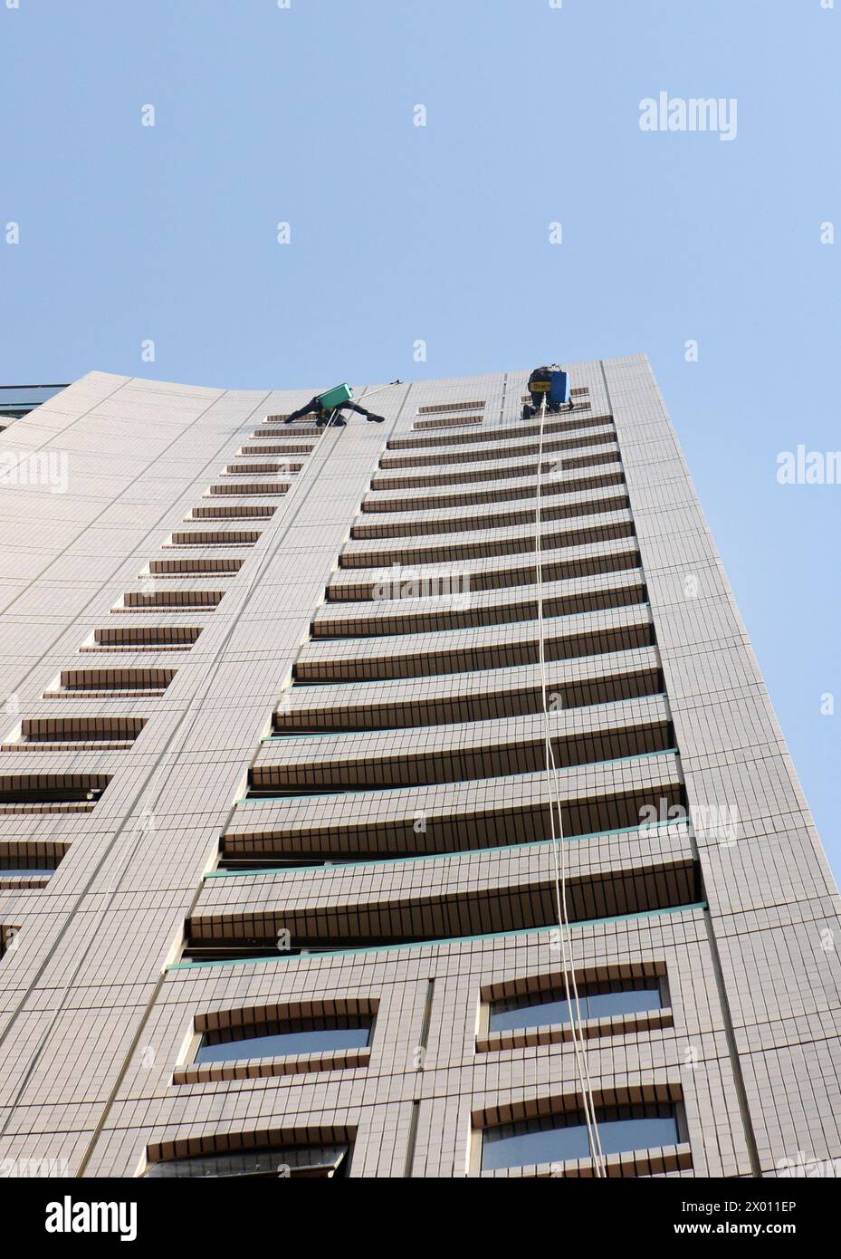 Fensterreiniger mit Seilzugang reinigen Fenster eines hohen Gebäudes in Deira, Dubai, VAE. Stockfoto