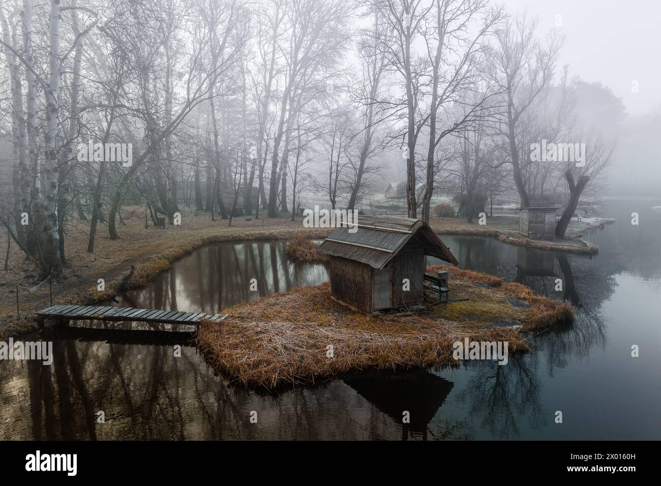 Szodliget, Ungarn - aus der Vogelperspektive eine traumhafte Winterszene am Szodliget Angelsee mit Fischerhütten und starkem Nebel an einem kalten Wintermorgen Stockfoto