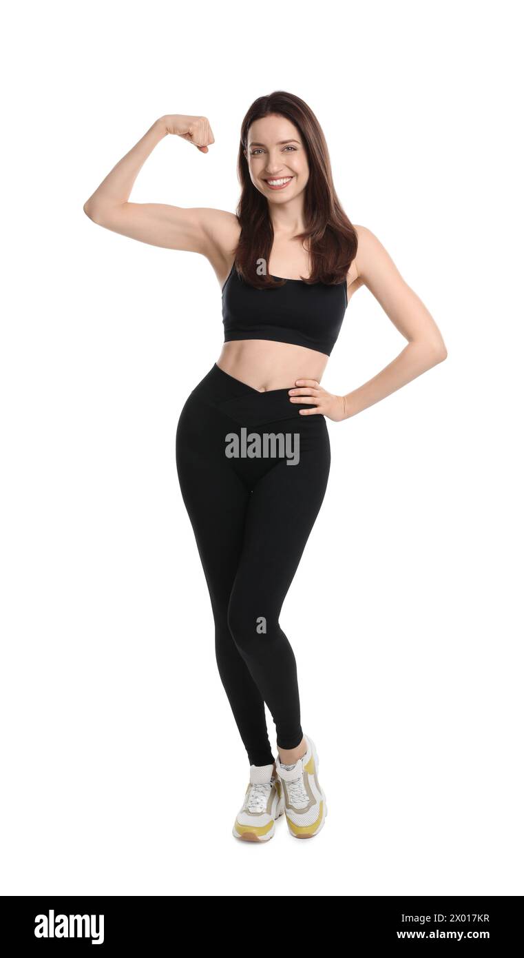Glückliche junge Frau mit schlankem Körper, der Muskeln auf weißem Hintergrund zeigt Stockfoto