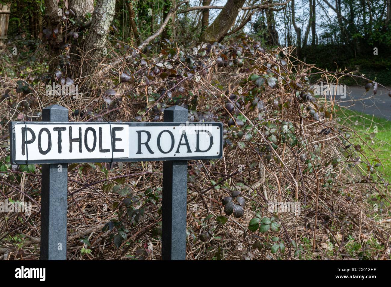 Pothole Road, Straßenschild mit tatsächlichem Straßennamen, ersetzt durch das Wort Pothole, wahrscheinlich von einem lokalen Fahrer, der frustriert ist, dass die Schlaglöcher nicht repariert werden, Großbritannien Stockfoto