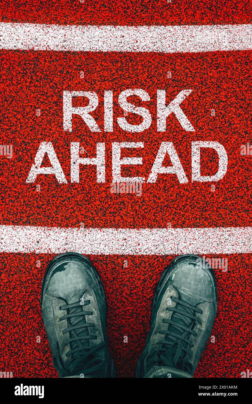 Risk Ahead Konzept, männliche Stiefel von oben mit Text auf dem Boden, Draufsicht Stockfoto