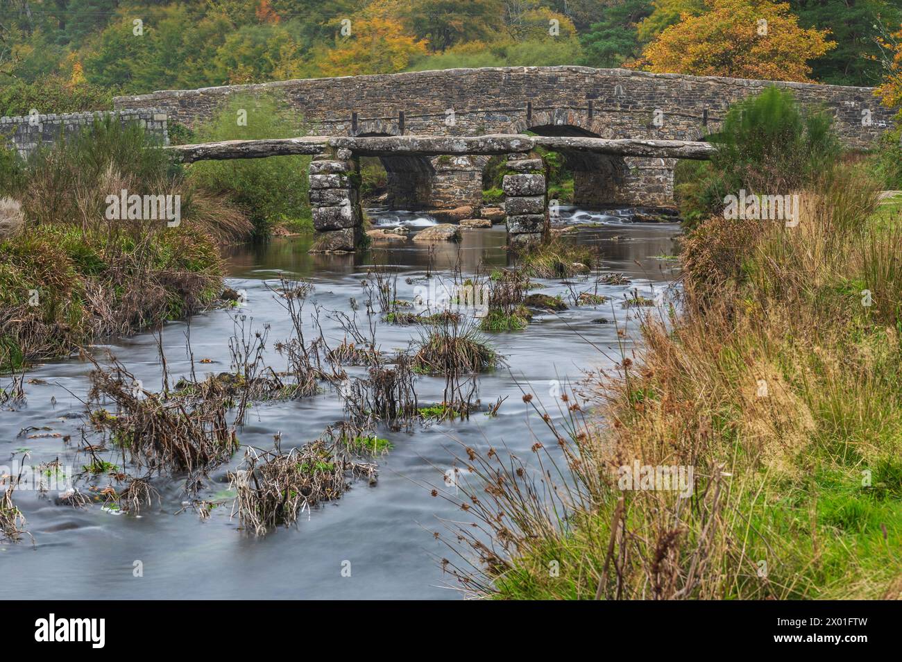 Die Steinklatschbrücke aus dem 13. Jahrhundert über den East Dart River im Dartmoor National Park bei Postbridge, Dartmoor, Devon, England Großbritannien Stockfoto